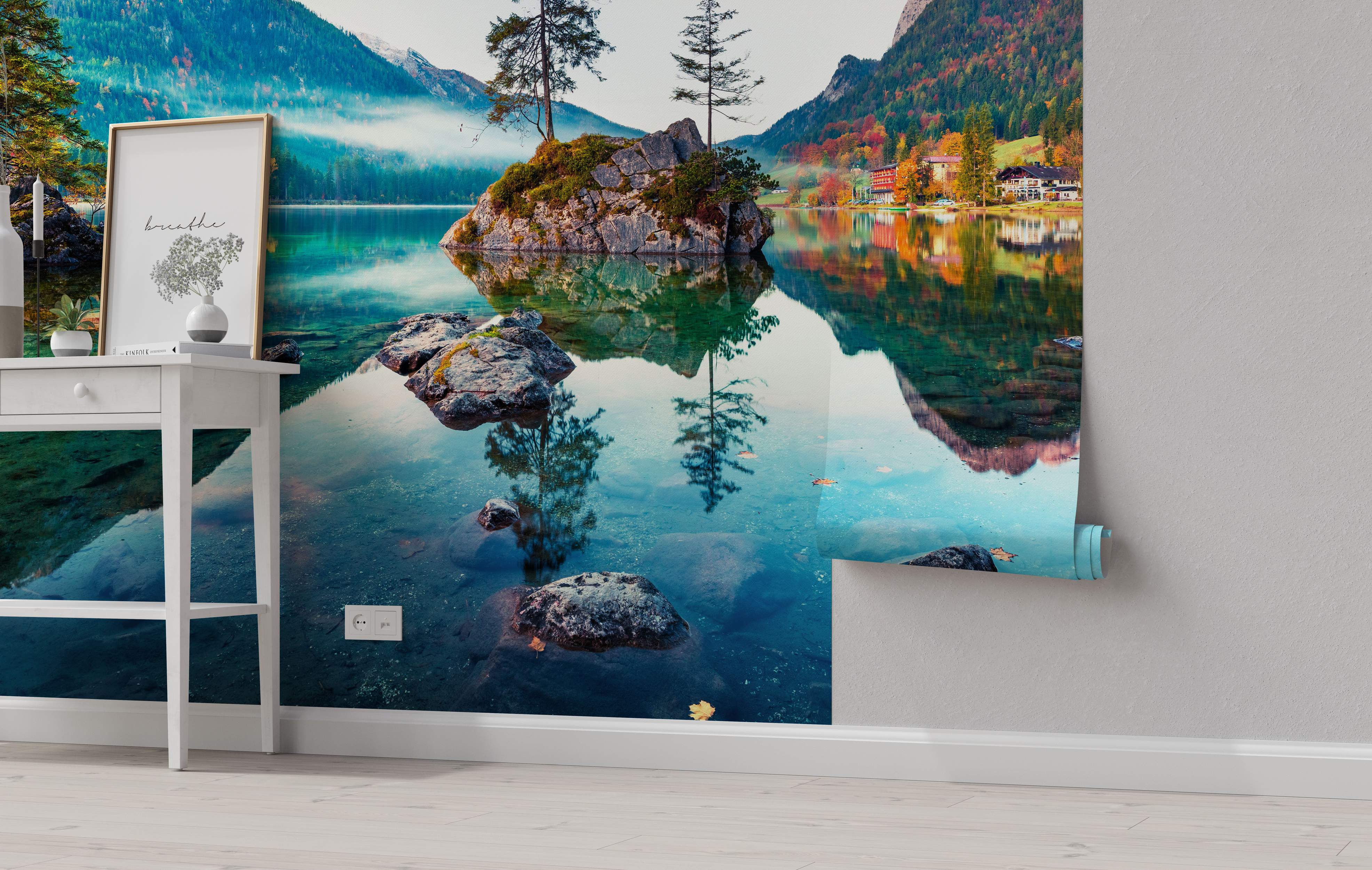 Mural of a serene alpine lake reflecting autumn-colored trees, misty mountains, and lakeside buildings in blues and greens.