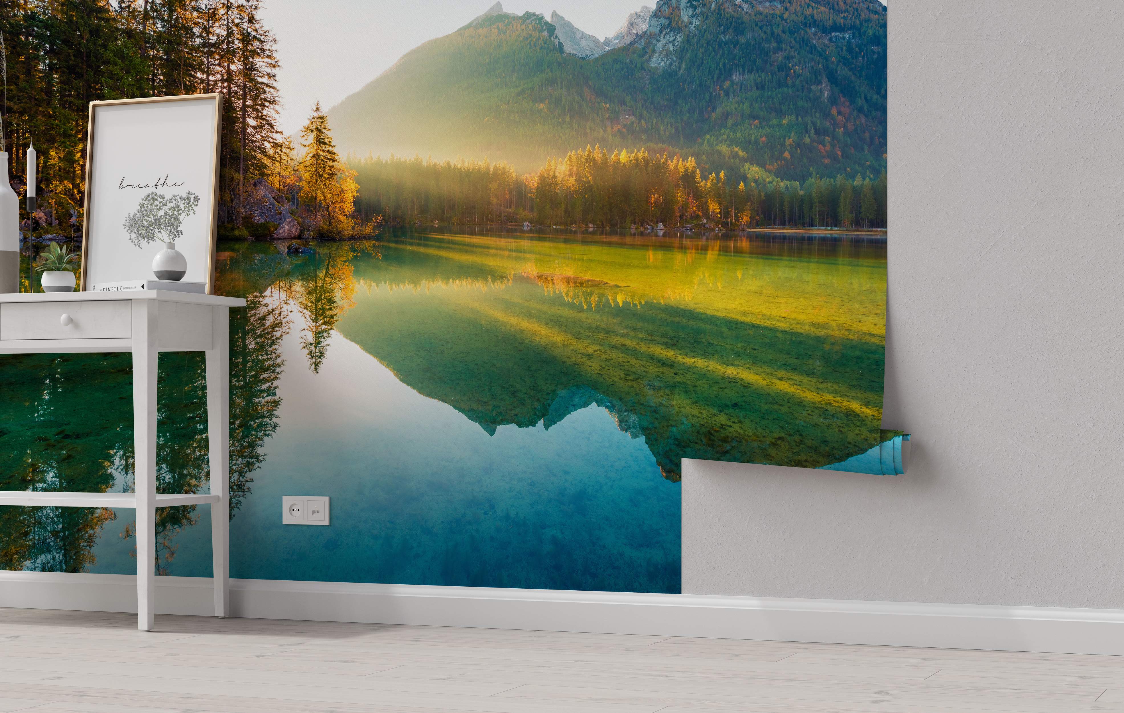 Mural depicting a calm lake reflecting mountains and golden autumn trees under a hazy sunrise, featuring blue, green, and yellow tones.