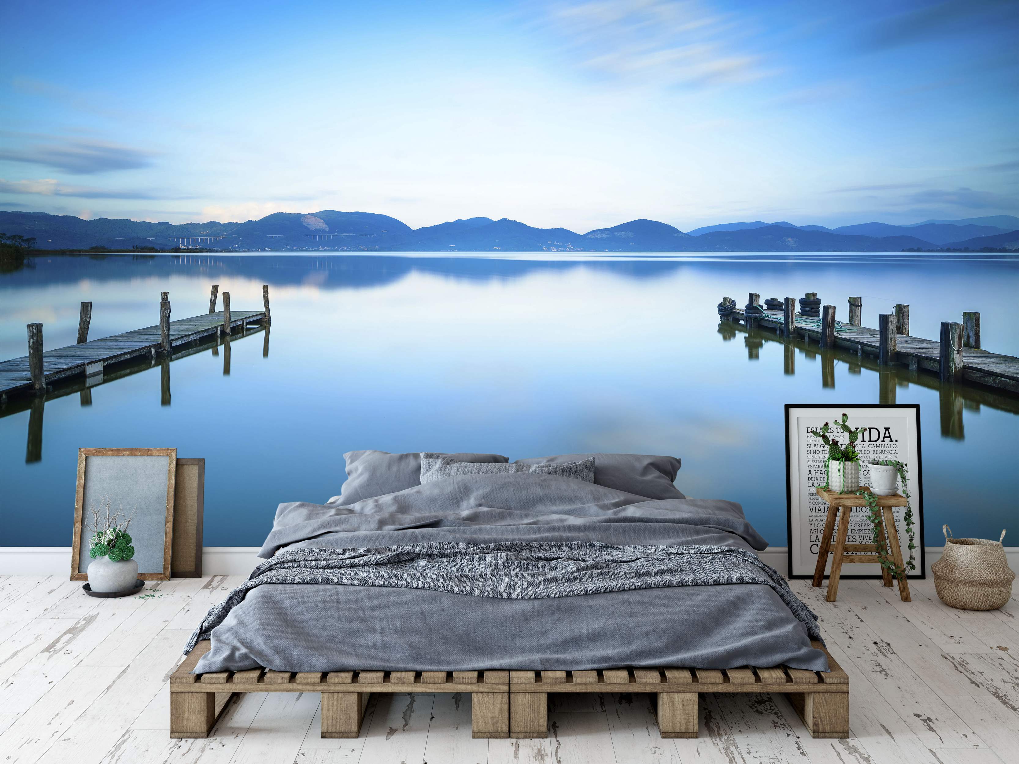 Photorealistic mural depicting a tranquil blue lake with wooden docks, water reflections, and distant mountains under a soft sky.
