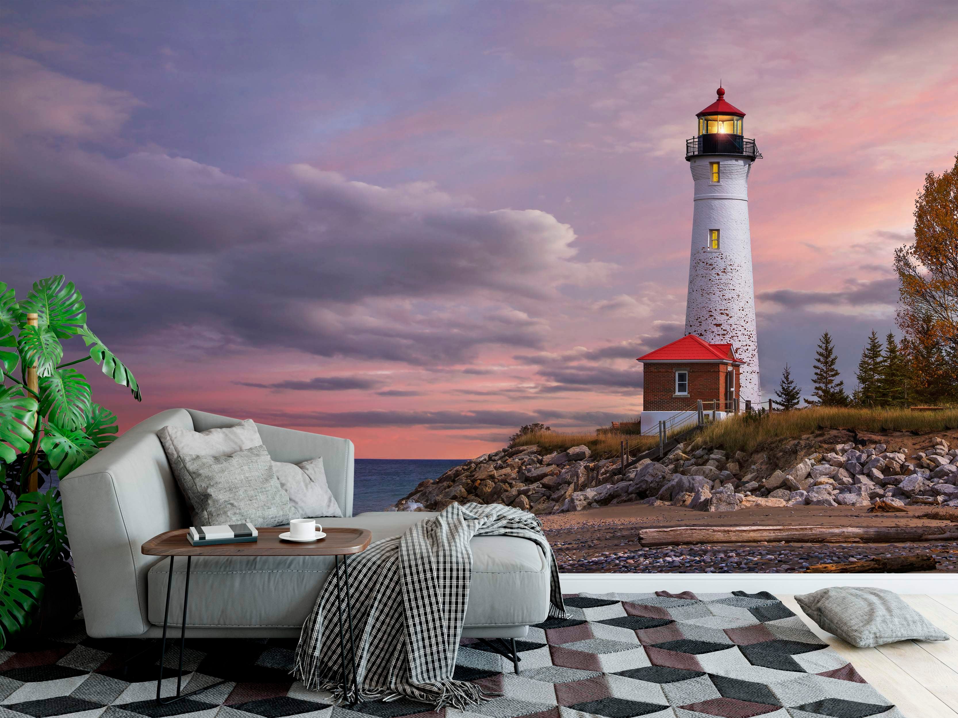 Coastal landscape mural depicting a white lighthouse with a red roof on a rocky shore under a dramatic purple and pink sunset sky.