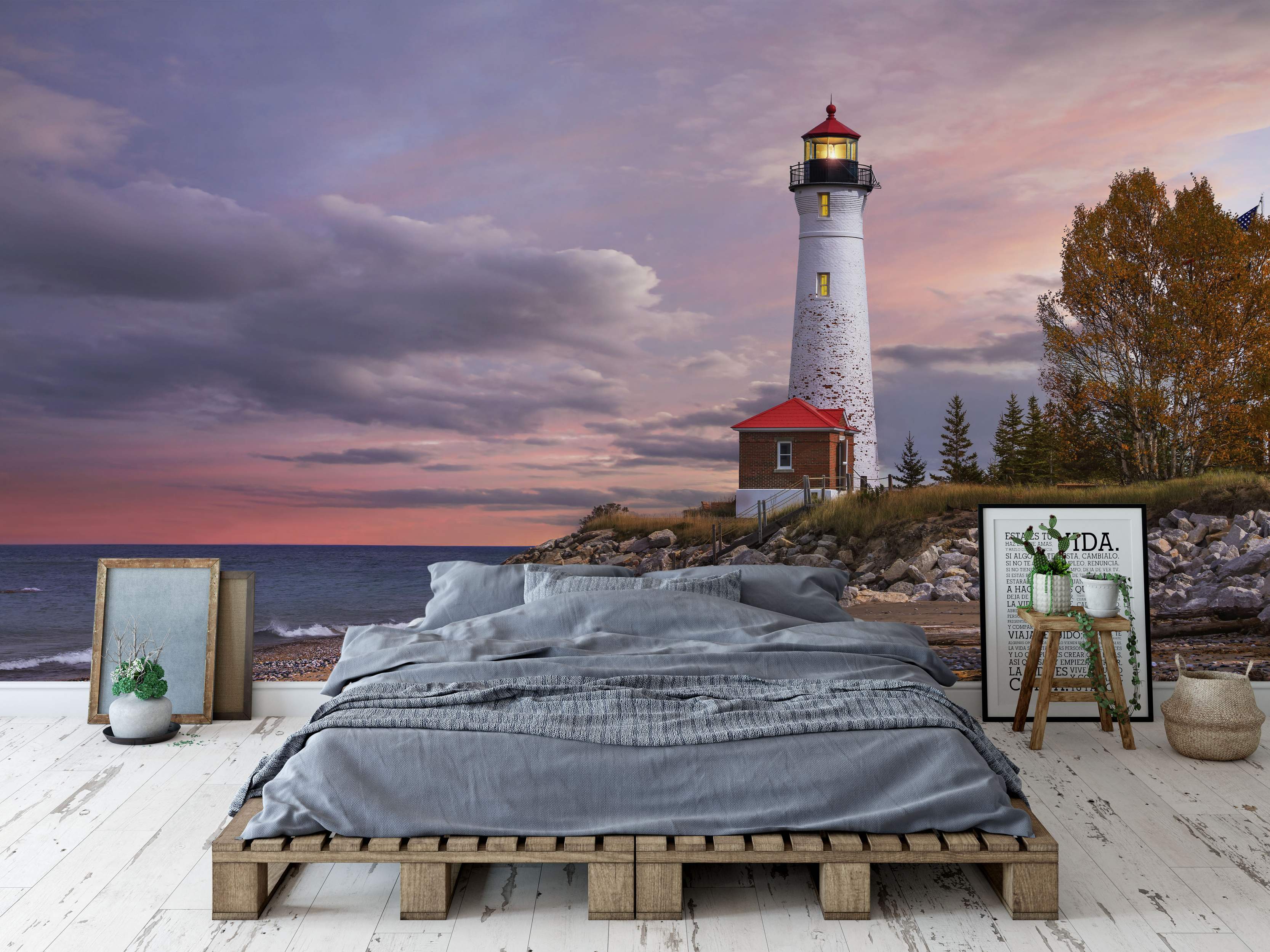 Mural depicting a coastal scene with a white lighthouse on rocks under a vibrant purple and orange sunset sky over the ocean.