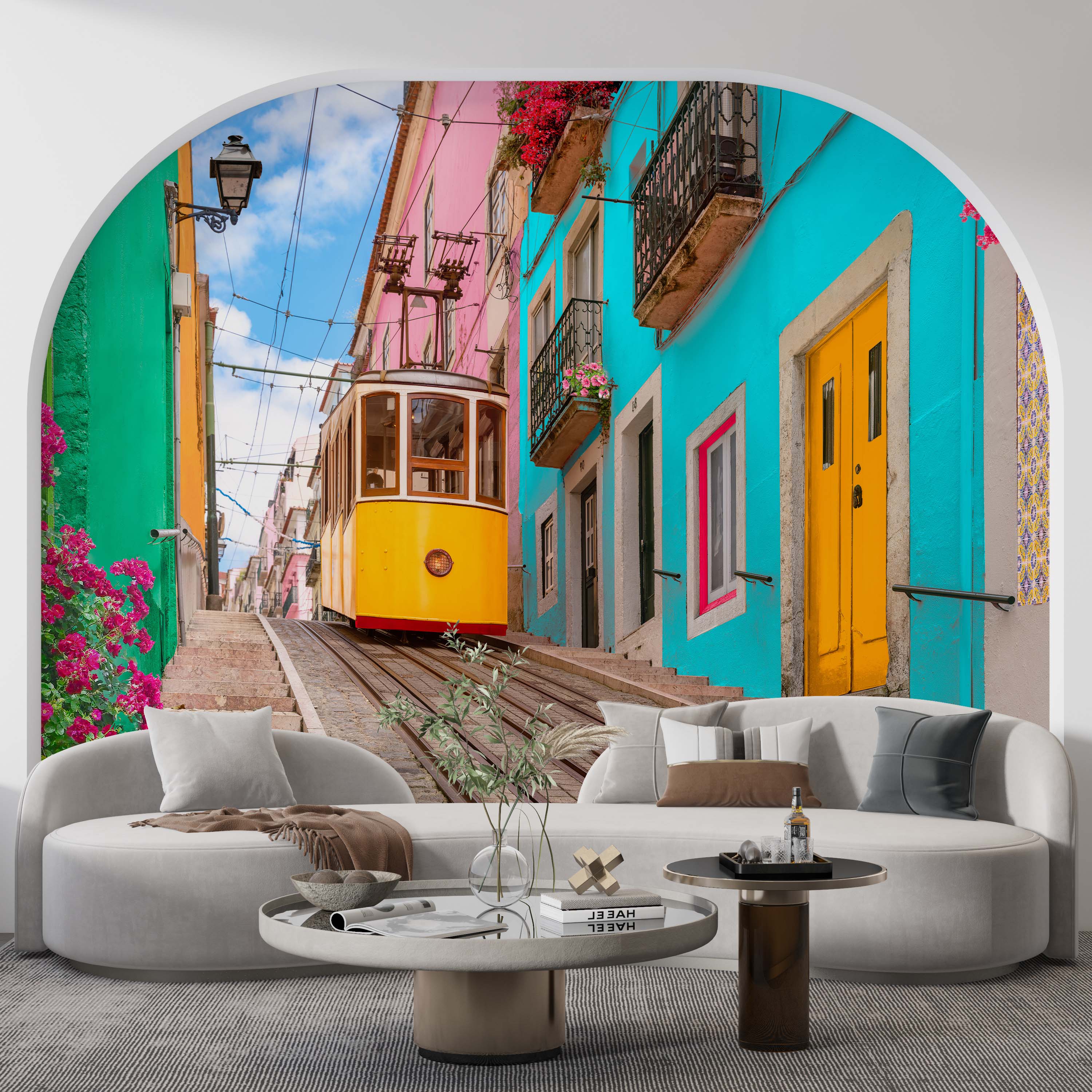 Mural of a yellow tram on a steep cobblestone street, framed by vibrant turquoise, pink, and green buildings.