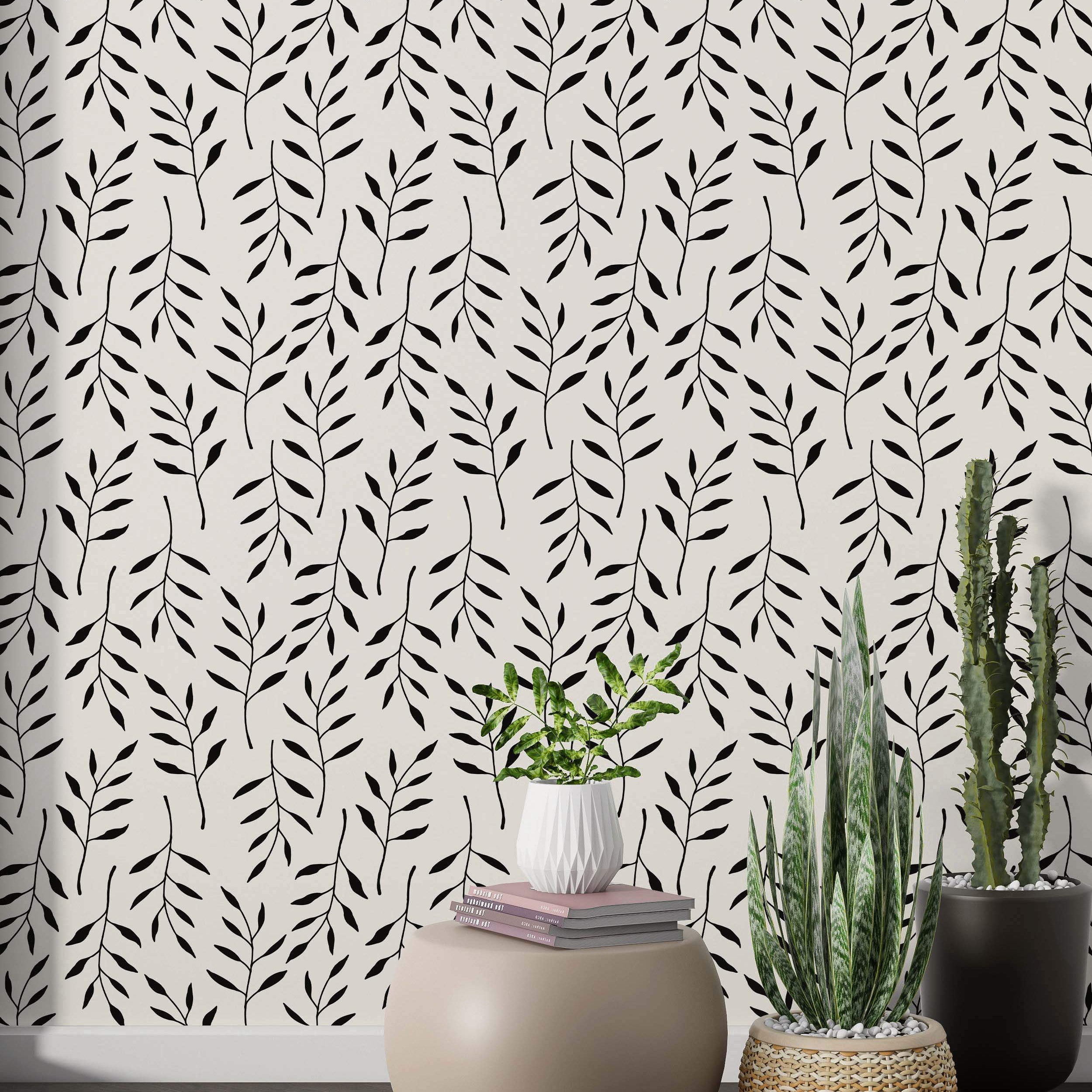 Minimalist wallpaper with a repeating pattern of simple black leafy branches on an off-white background.