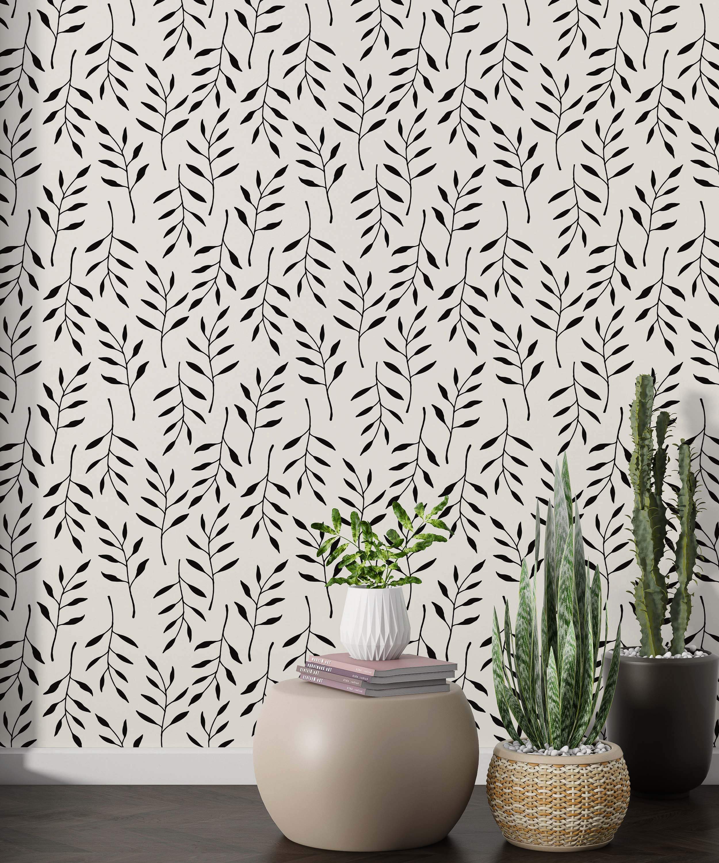 Minimalist wallpaper with a repeating pattern of simple black leafy branches on an off-white background.