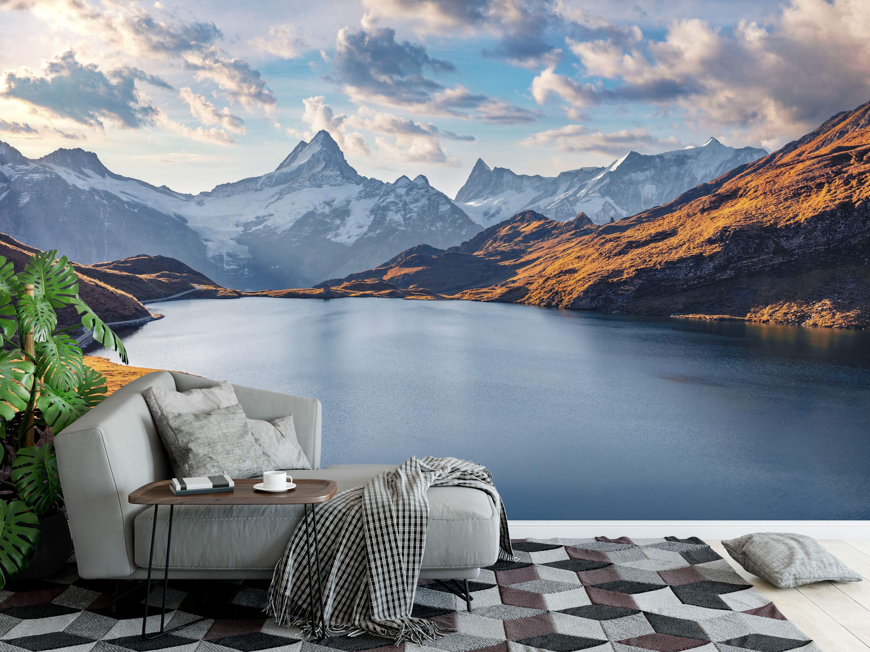 Photorealistic mural of majestic snow-capped mountains encircling a tranquil blue lake beneath a cloudy sky at sunset.