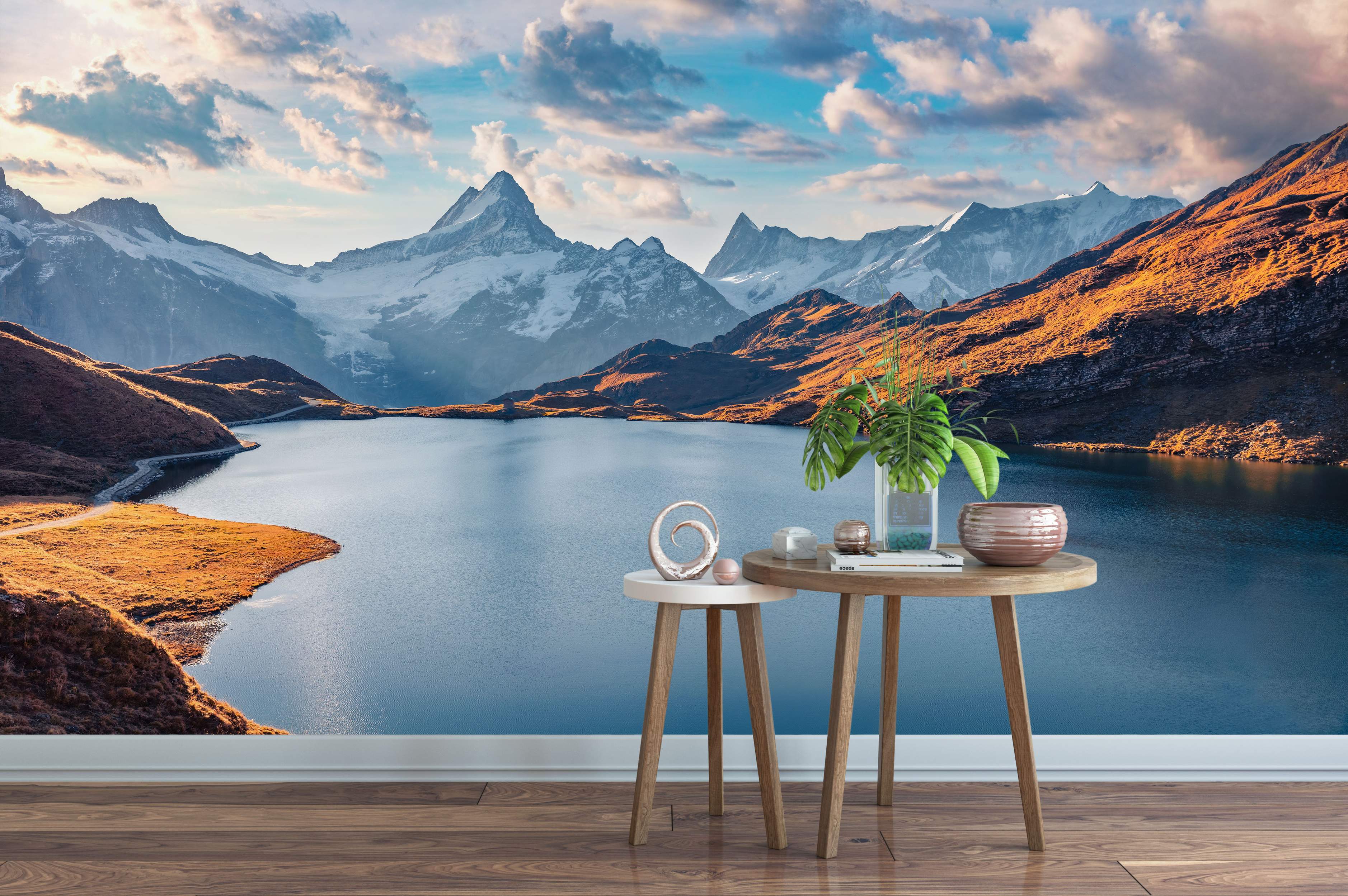 Scenic mountain landscape mural with a blue lake, golden hillsides, snow-capped peaks, and a cloudy blue sky at sunset.