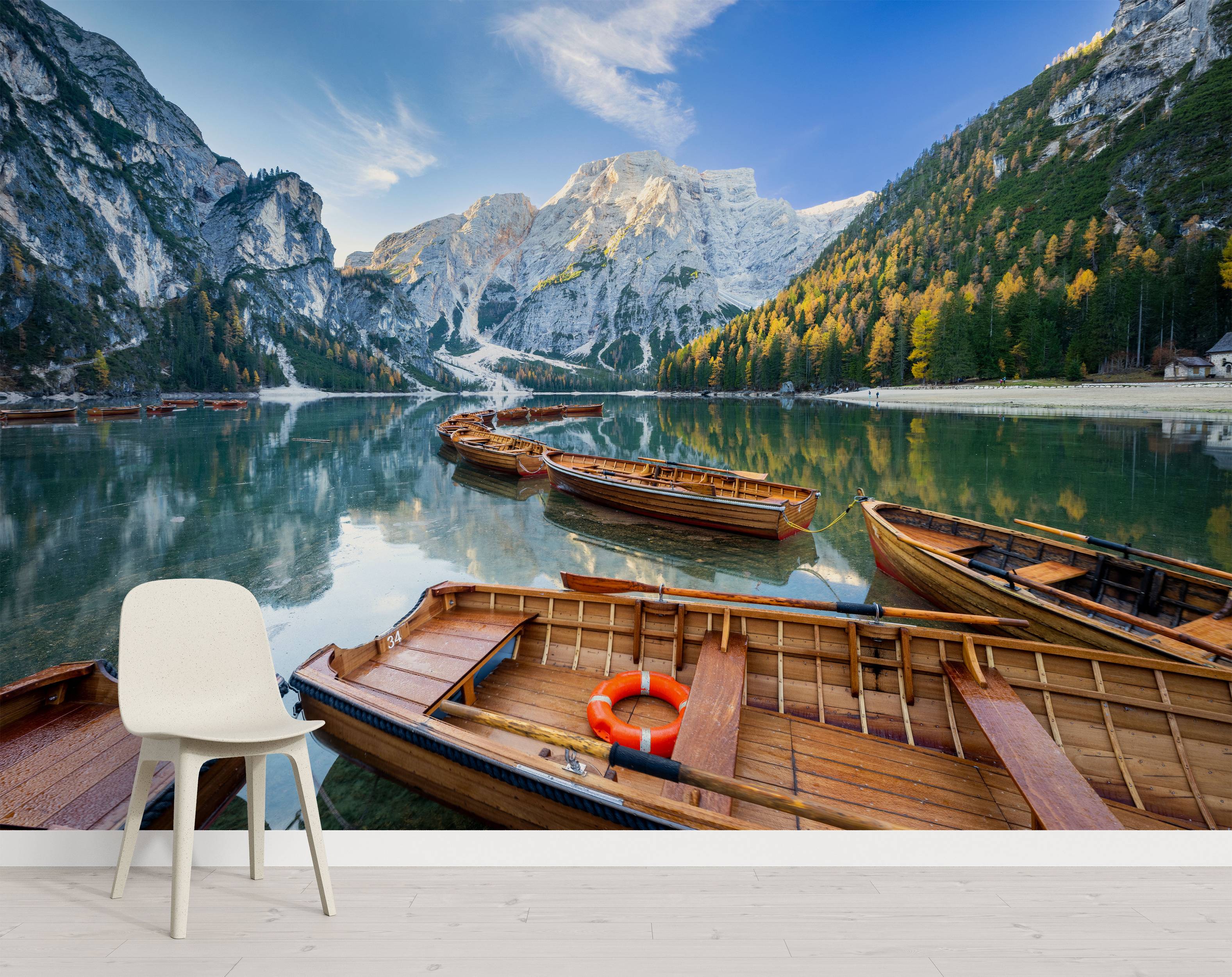 A scenic mural of wooden rowboats on a calm lake, surrounded by autumn forests and snow-capped mountains under a blue sky.