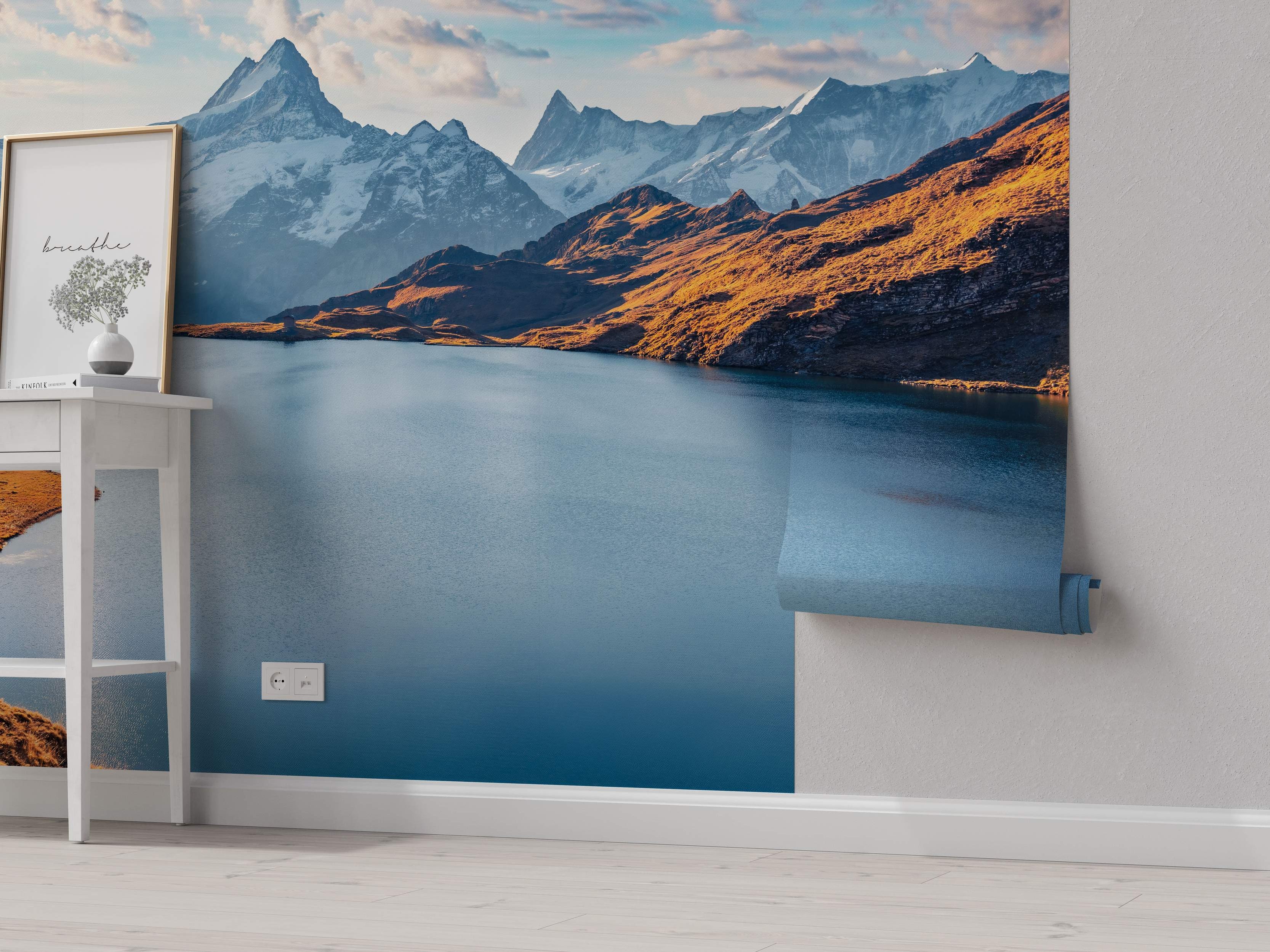 Mountain landscape mural showing a blue alpine lake surrounded by golden hills and distant snow-covered peaks.