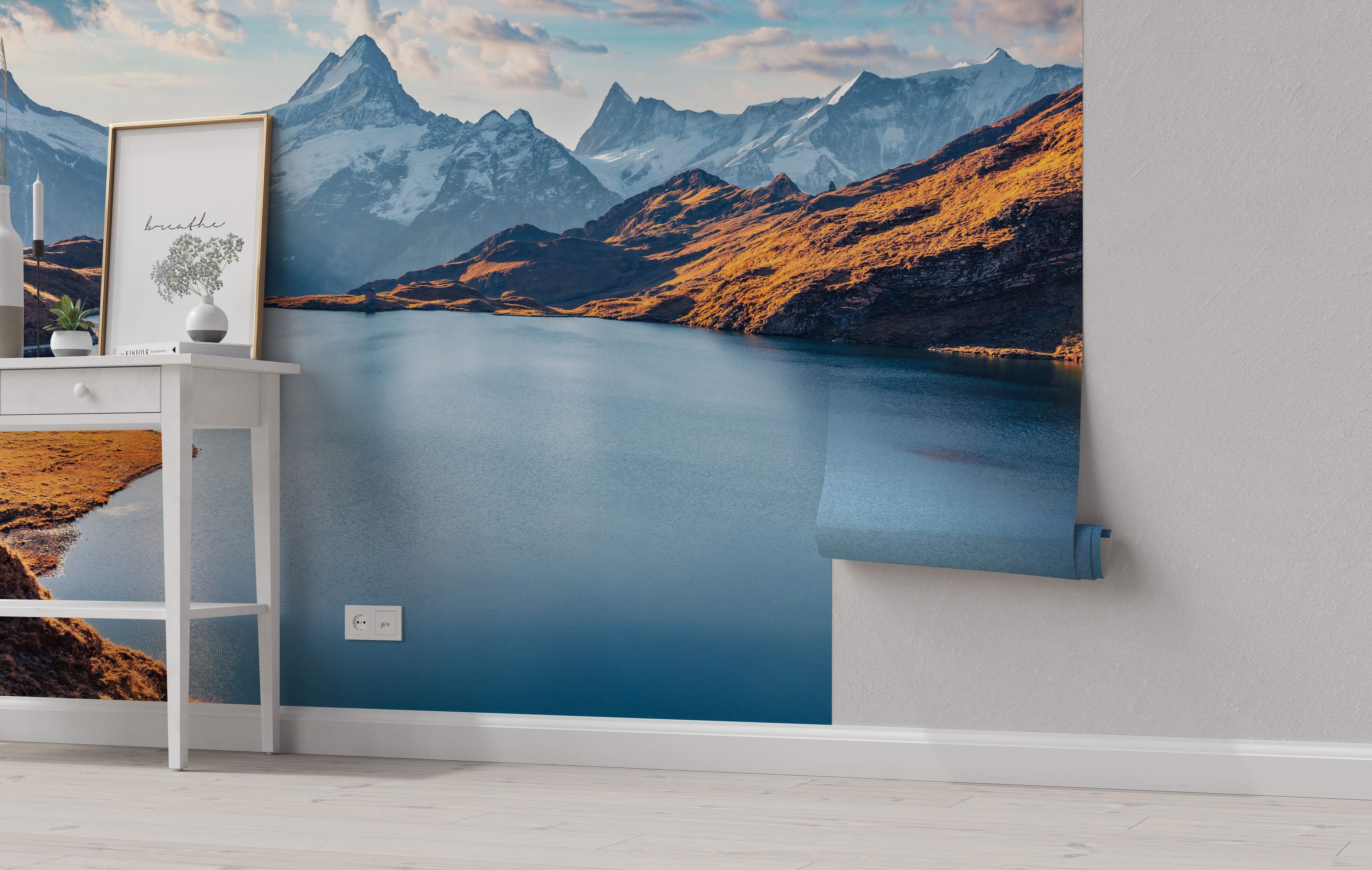 Mountain landscape mural showing a blue alpine lake surrounded by golden hills and distant snow-covered peaks.
