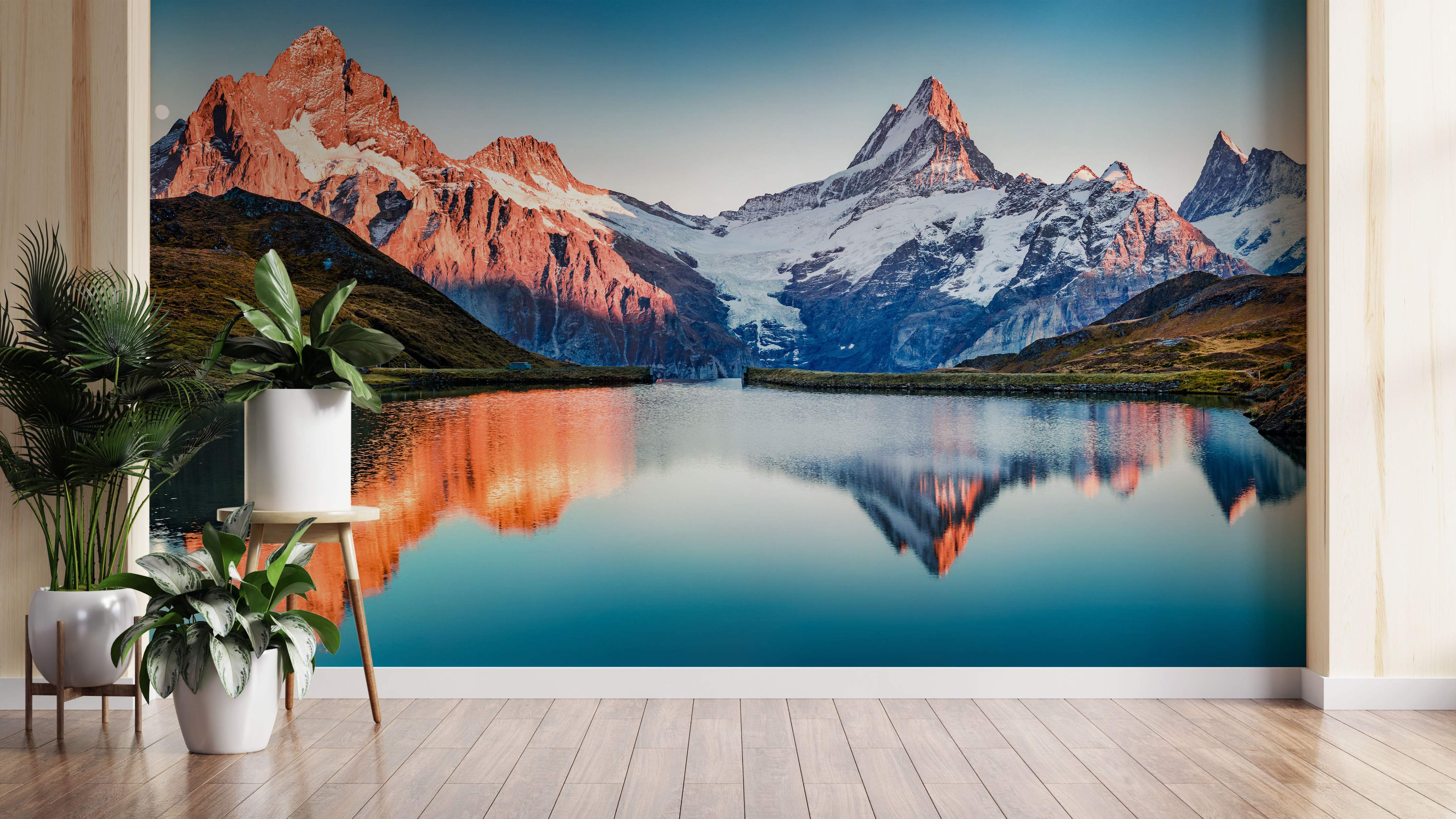 Scenic mountain landscape mural featuring reddish-orange peaks reflected in a calm, deep blue lake under a clear sky.