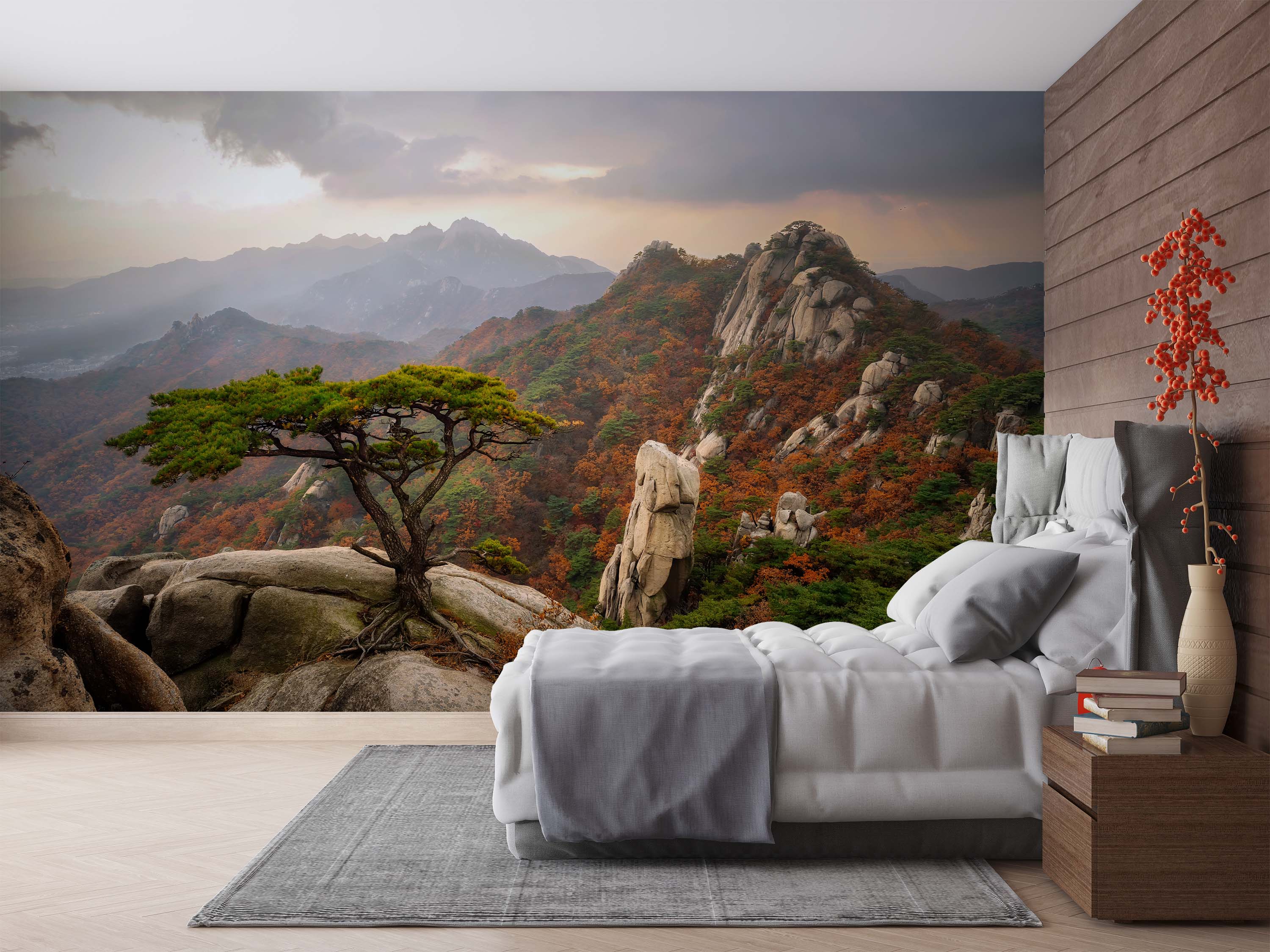 Mural of a mountain landscape in autumn, featuring a pine tree on a rocky outcrop, colorful foliage, and misty peaks under a cloudy sky.