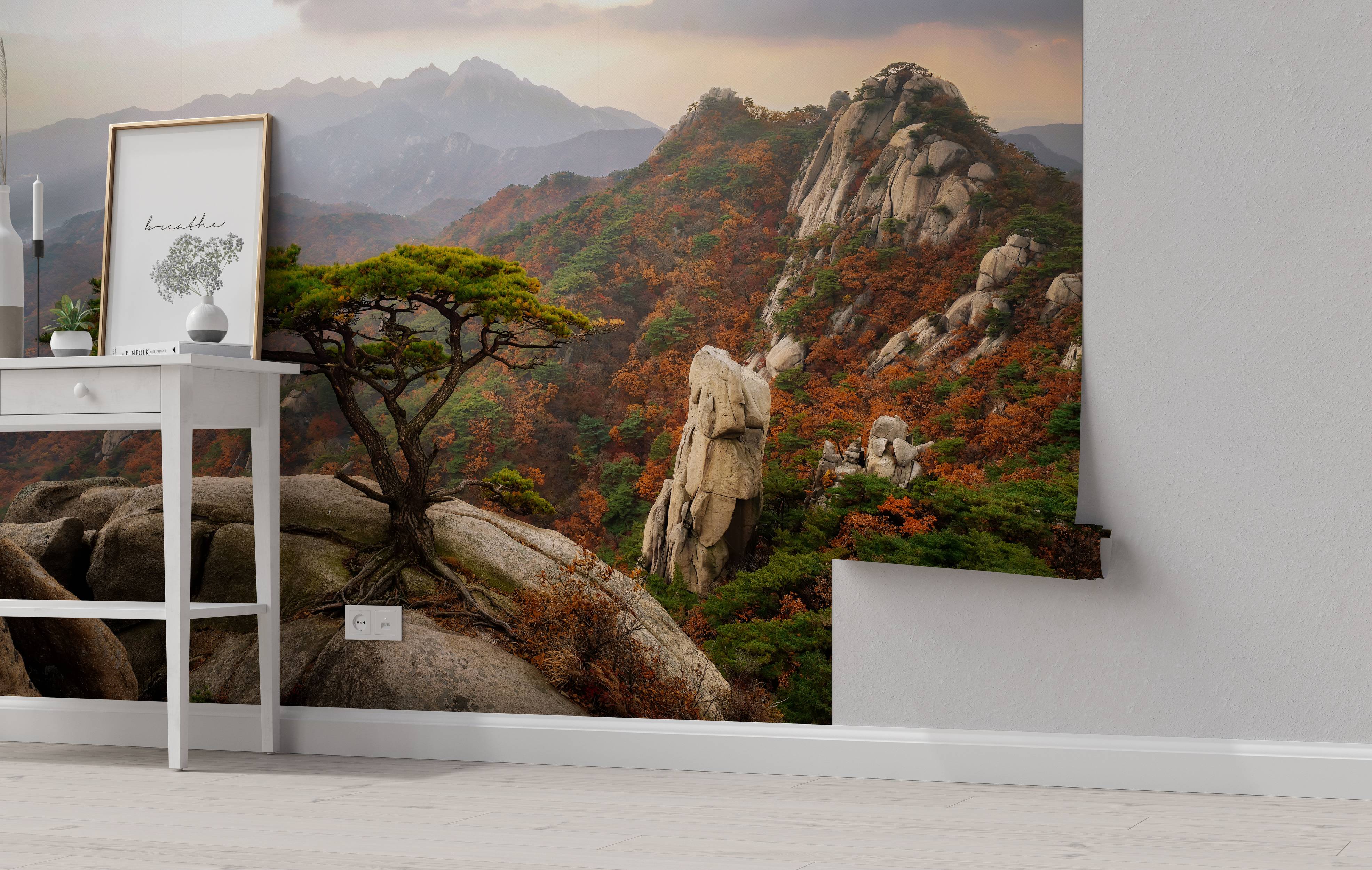 A photorealistic mural of a rocky mountain landscape in autumn, with green pines and orange foliage under a hazy sky.