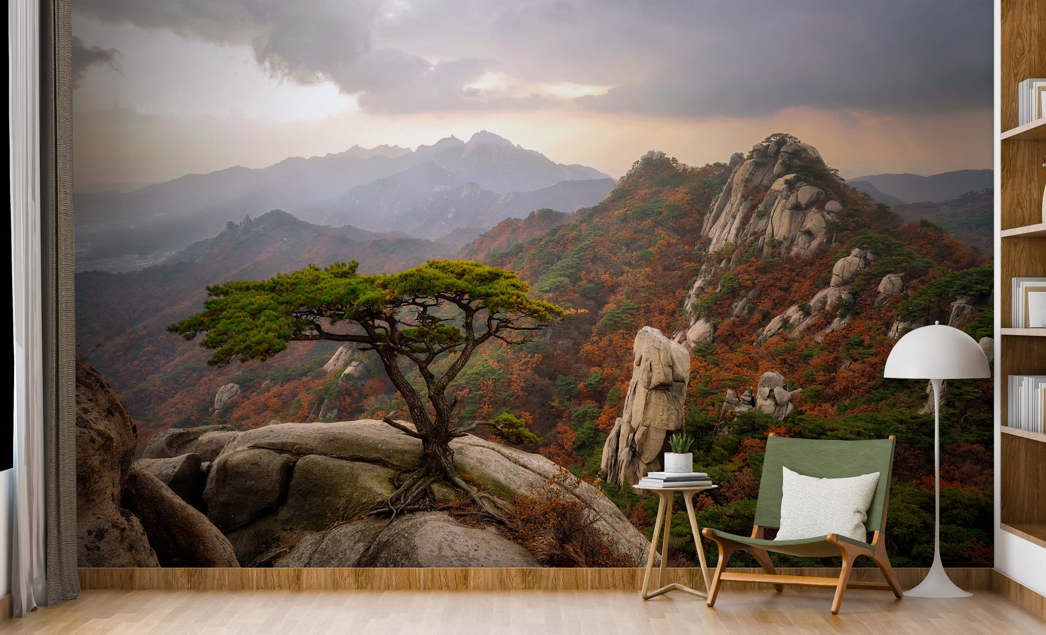 A scenic wall mural of an autumn mountain landscape. A gnarled pine tree sits on a rocky foreground, overlooking a valley.