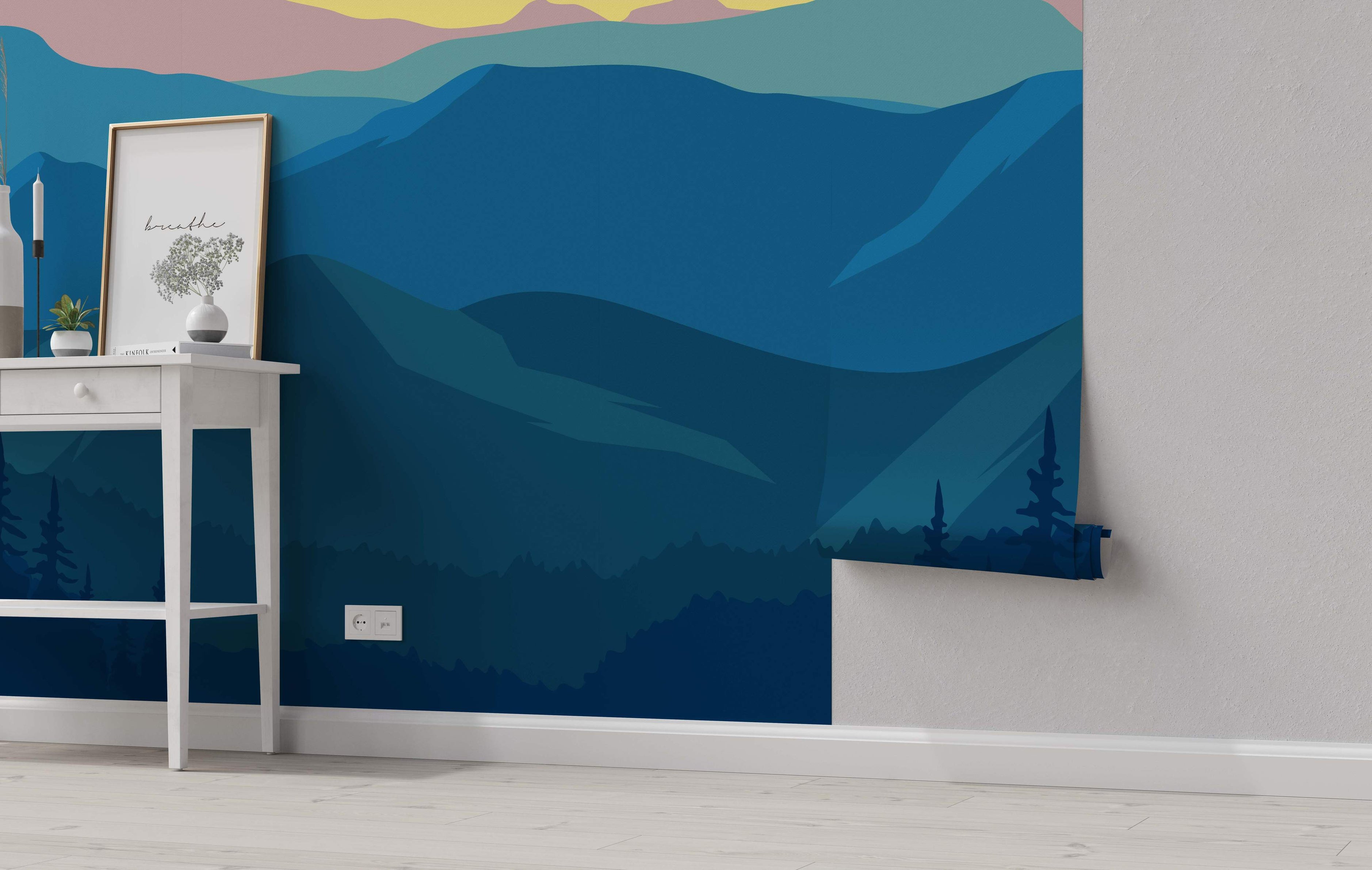 Stylized mountain landscape mural with layered hills in blue shades under a pink and yellow sky, featuring dark tree silhouettes.