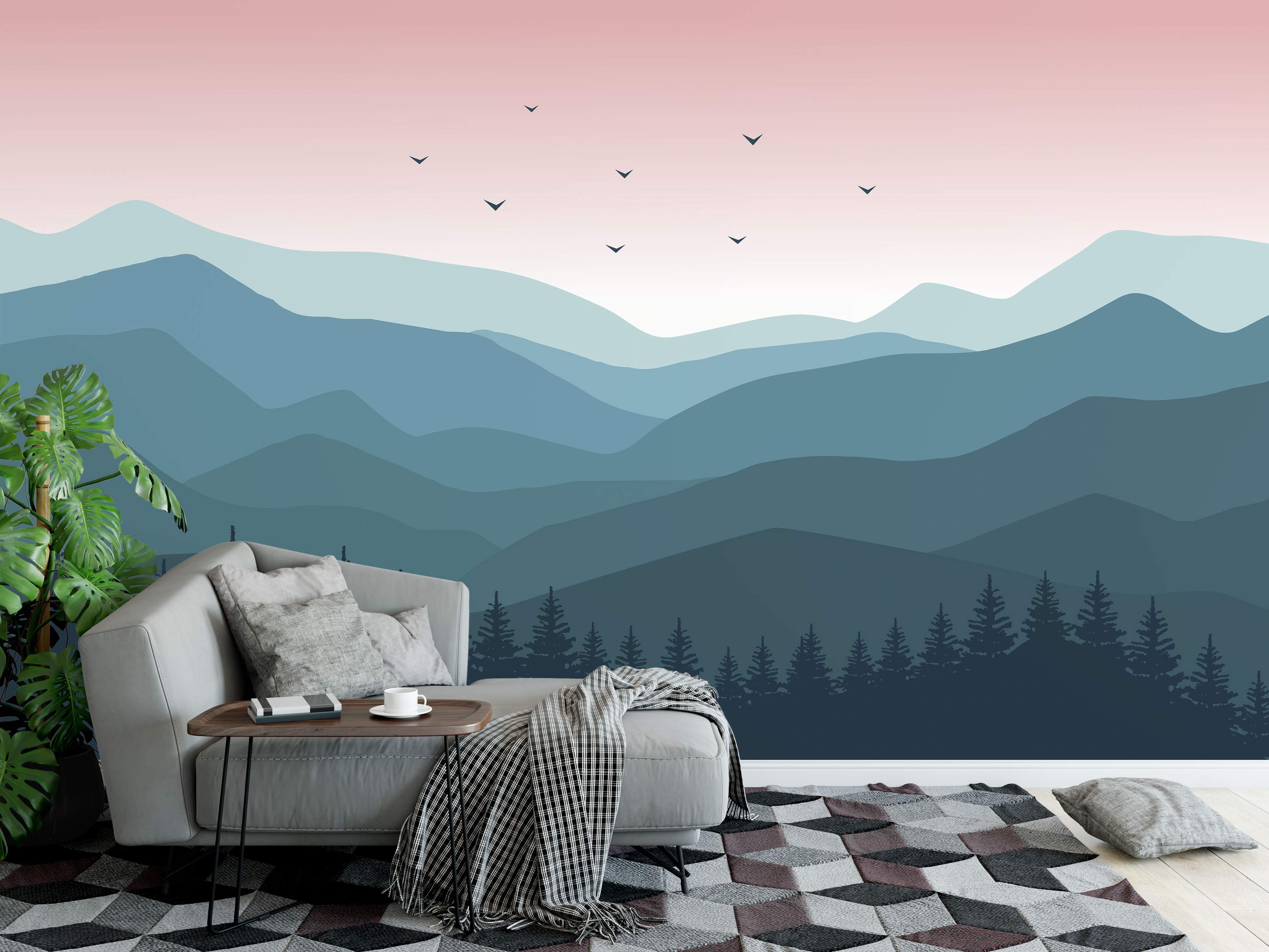 Minimalist landscape mural with layered blue mountains, pink gradient sky, bird silhouettes, and dark forest trees.