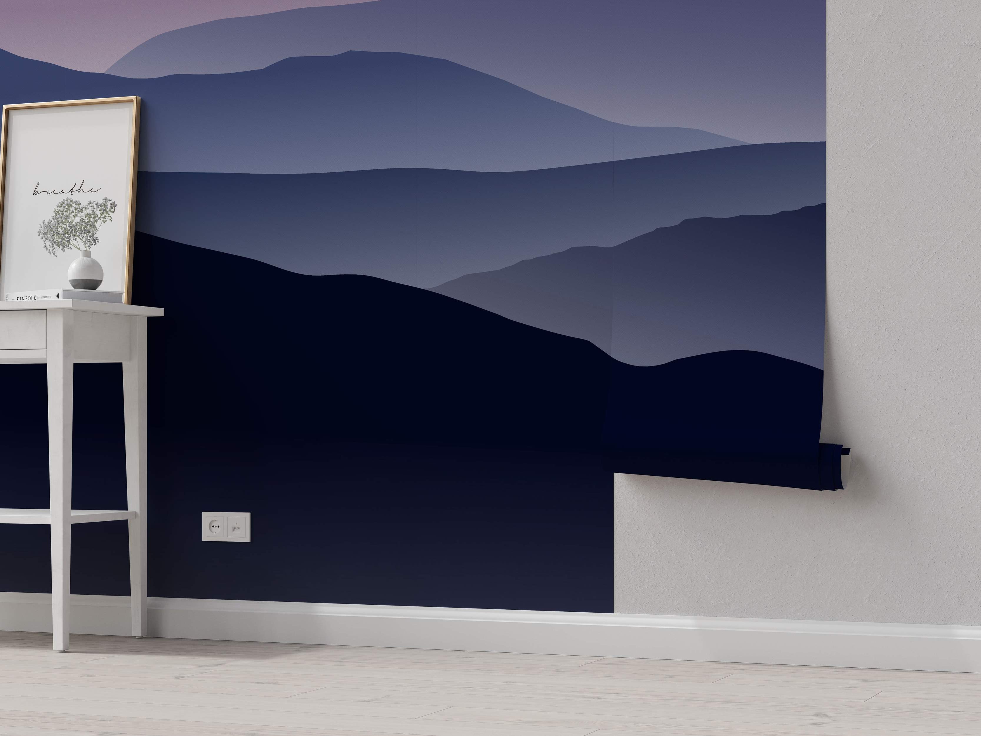 Stylized mountain range mural with layered silhouettes fading from dark navy blue to lighter blue and hazy purple.