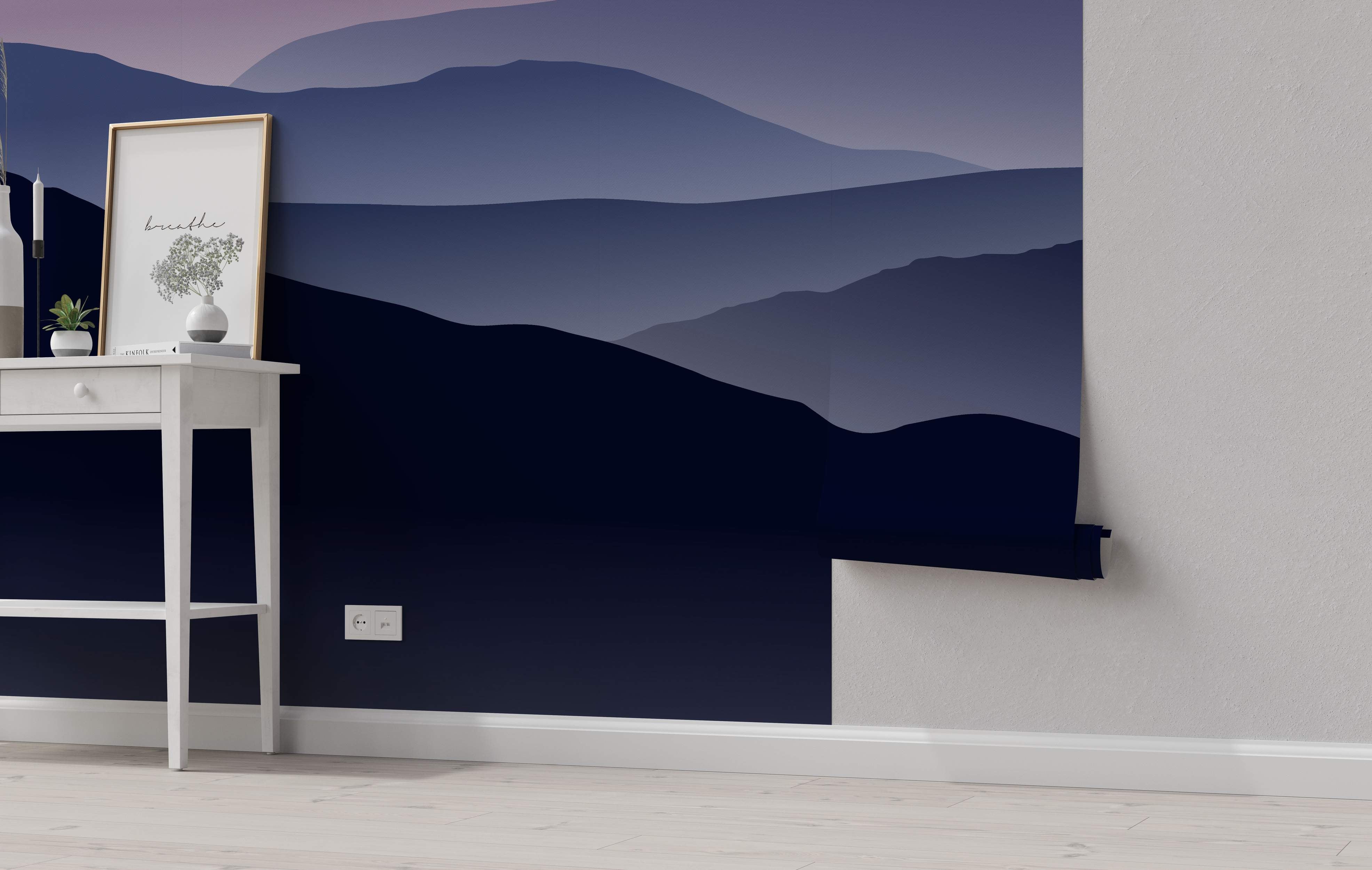 Stylized mountain range mural with layered silhouettes fading from dark navy blue to lighter blue and hazy purple.