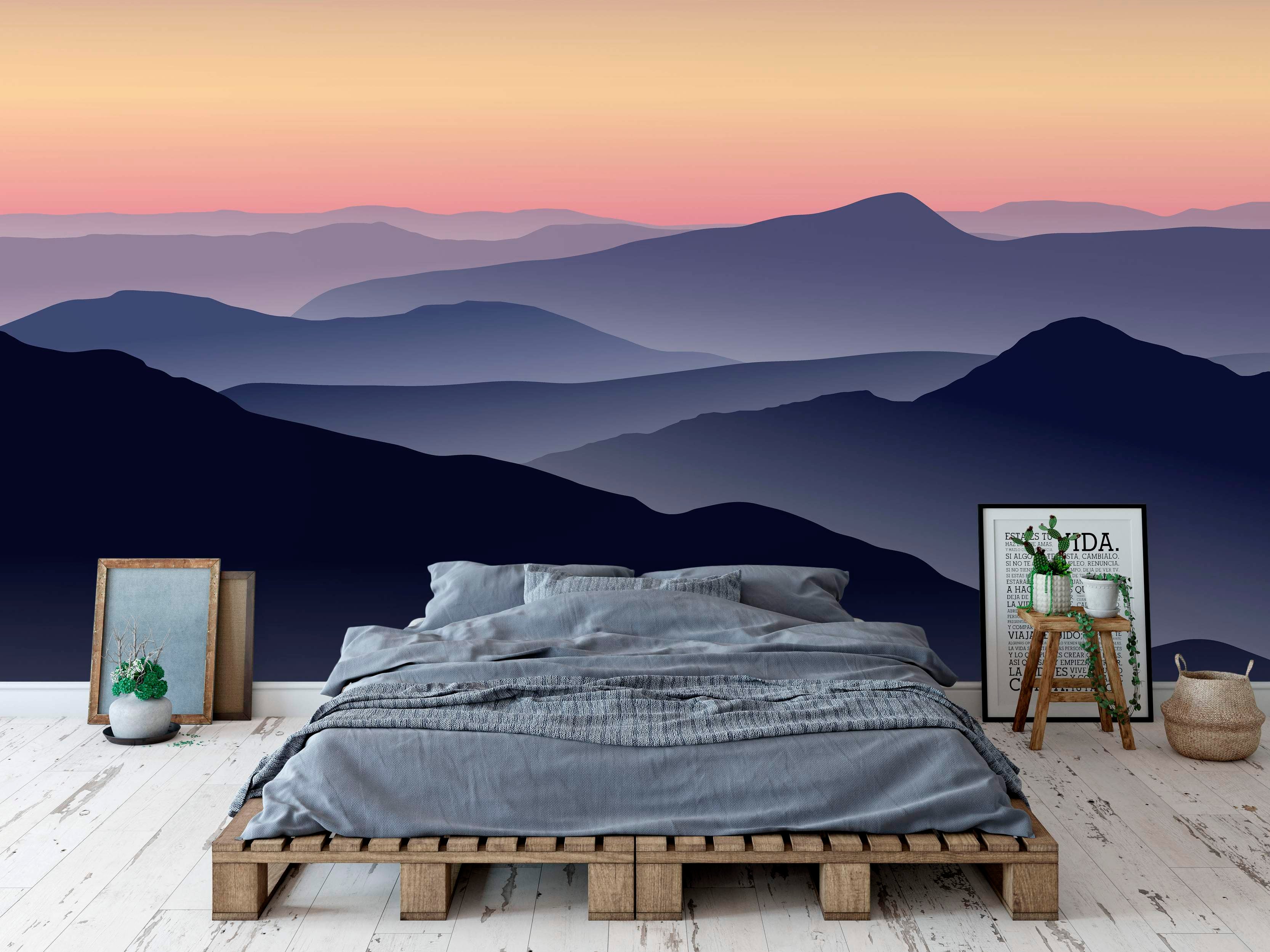Mountain landscape mural featuring layered silhouettes in deep blue and purple under a pink and orange gradient sunset sky.