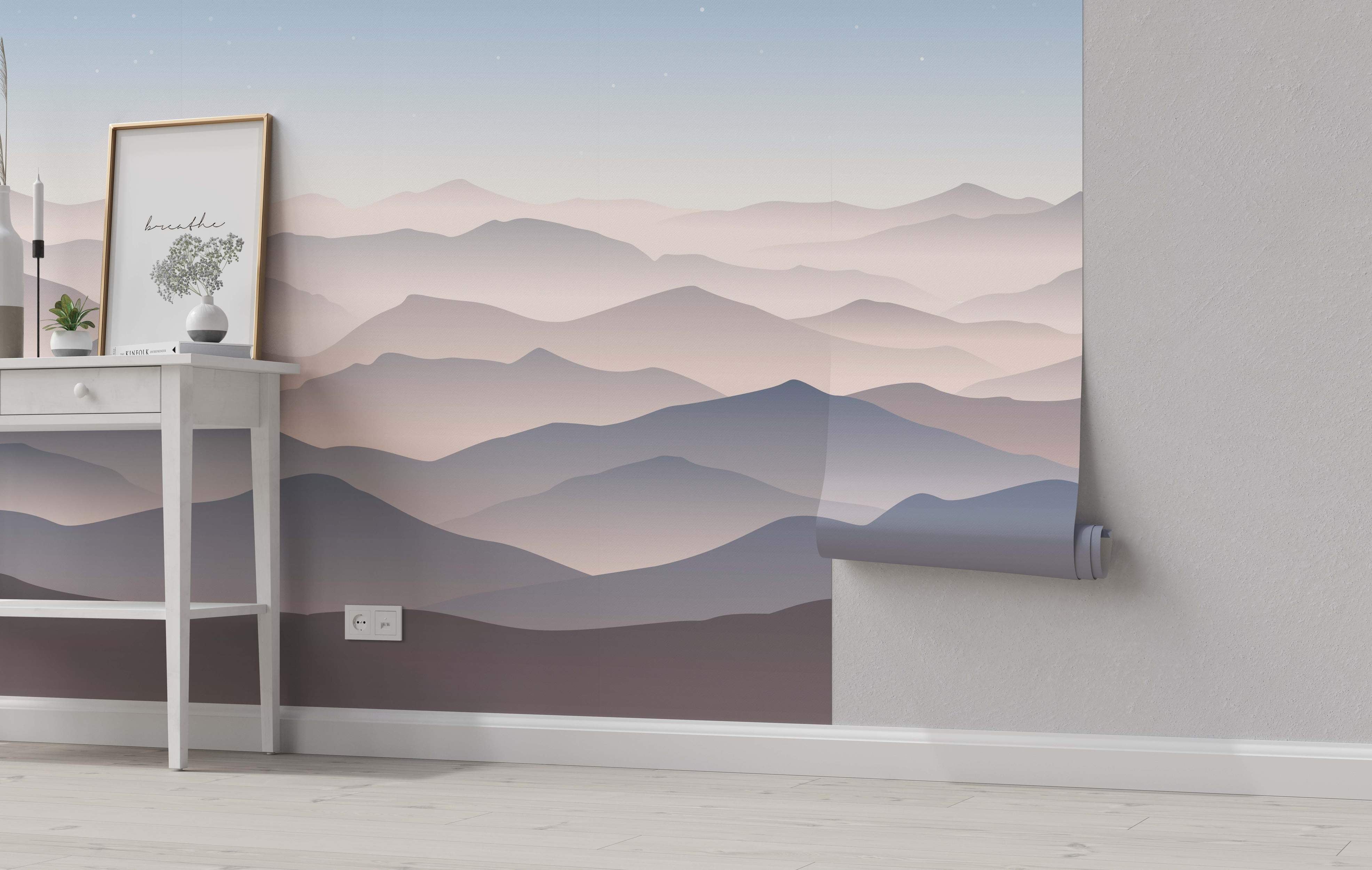 Minimalist mountain landscape mural featuring layered ranges in soft, hazy pink, mauve, and blue tones under a pale starry sky.
