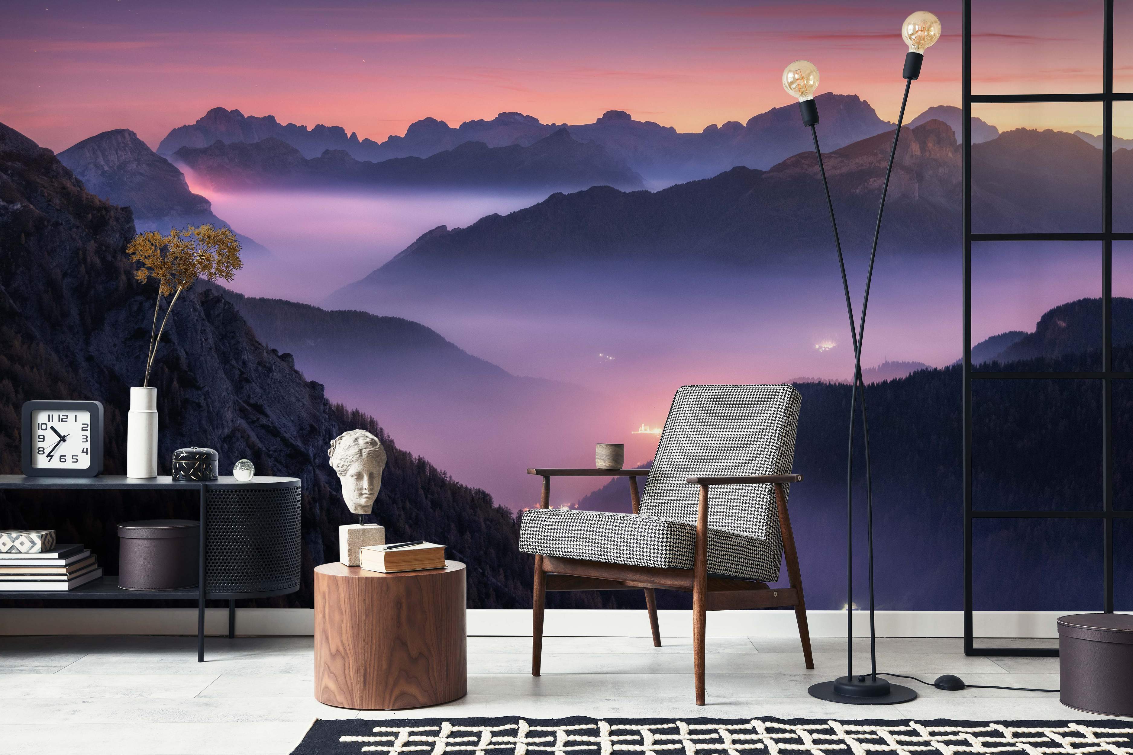 Mural depicting a misty mountain range at sunset, with purple, pink, and orange sky gradients above dark peaks.