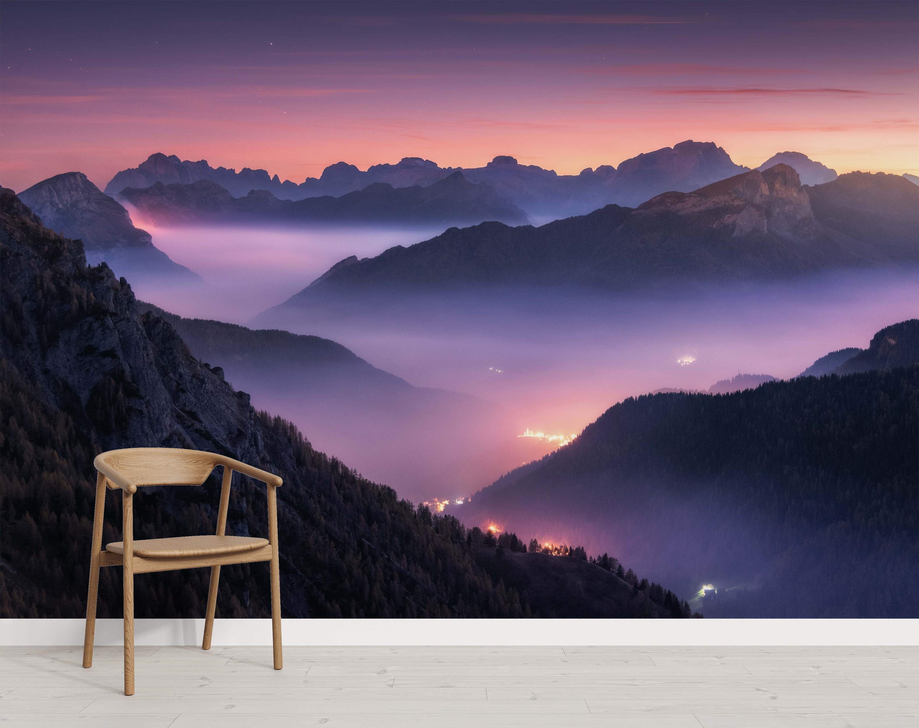 Mural depicting a hazy mountain valley at twilight. Pink and purple sky above, glowing lights visible through the mist.