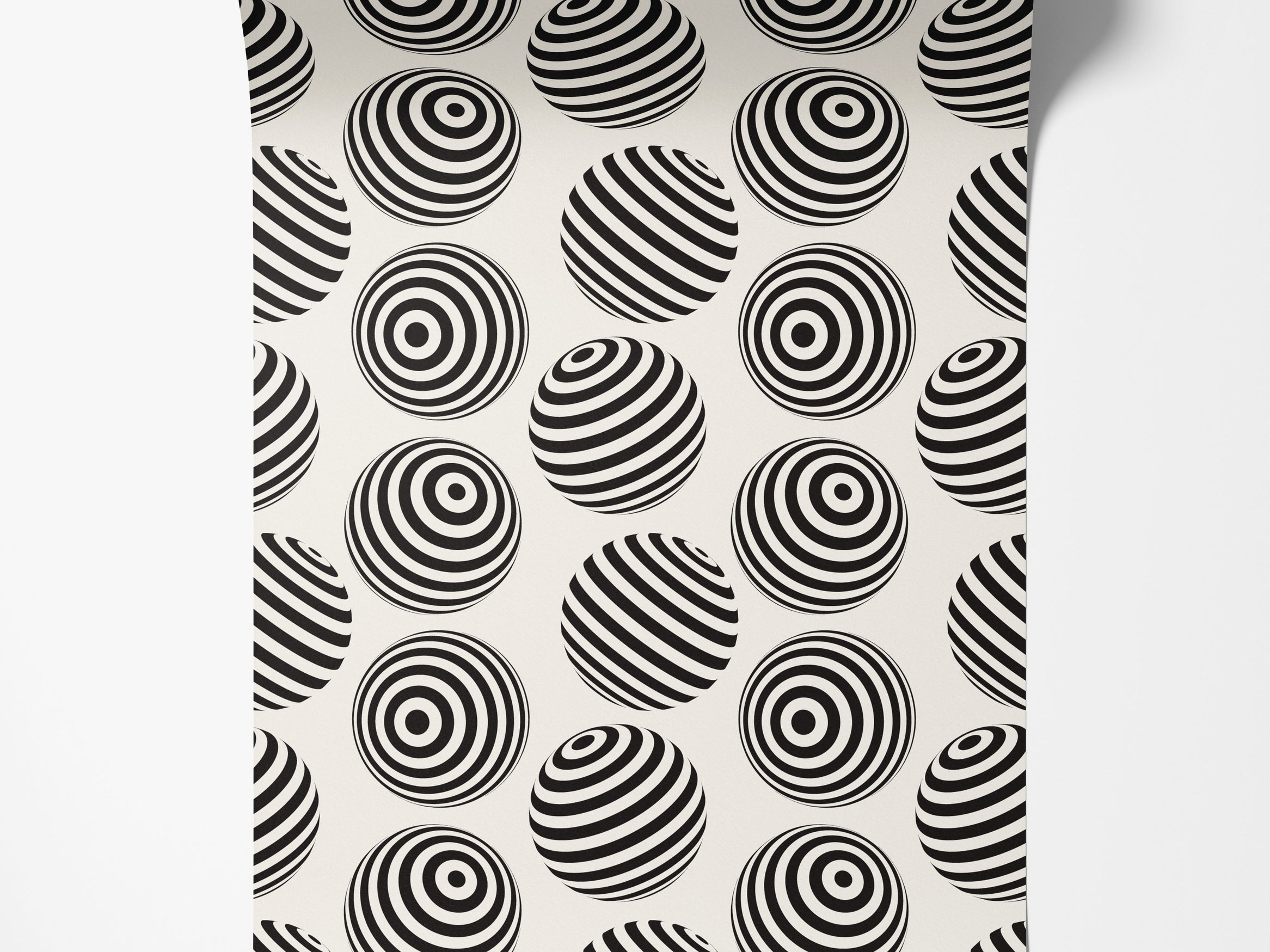 Wallpaper with an op-art pattern of black and off-white spheres, detailed with concentric rings or diagonal stripes.