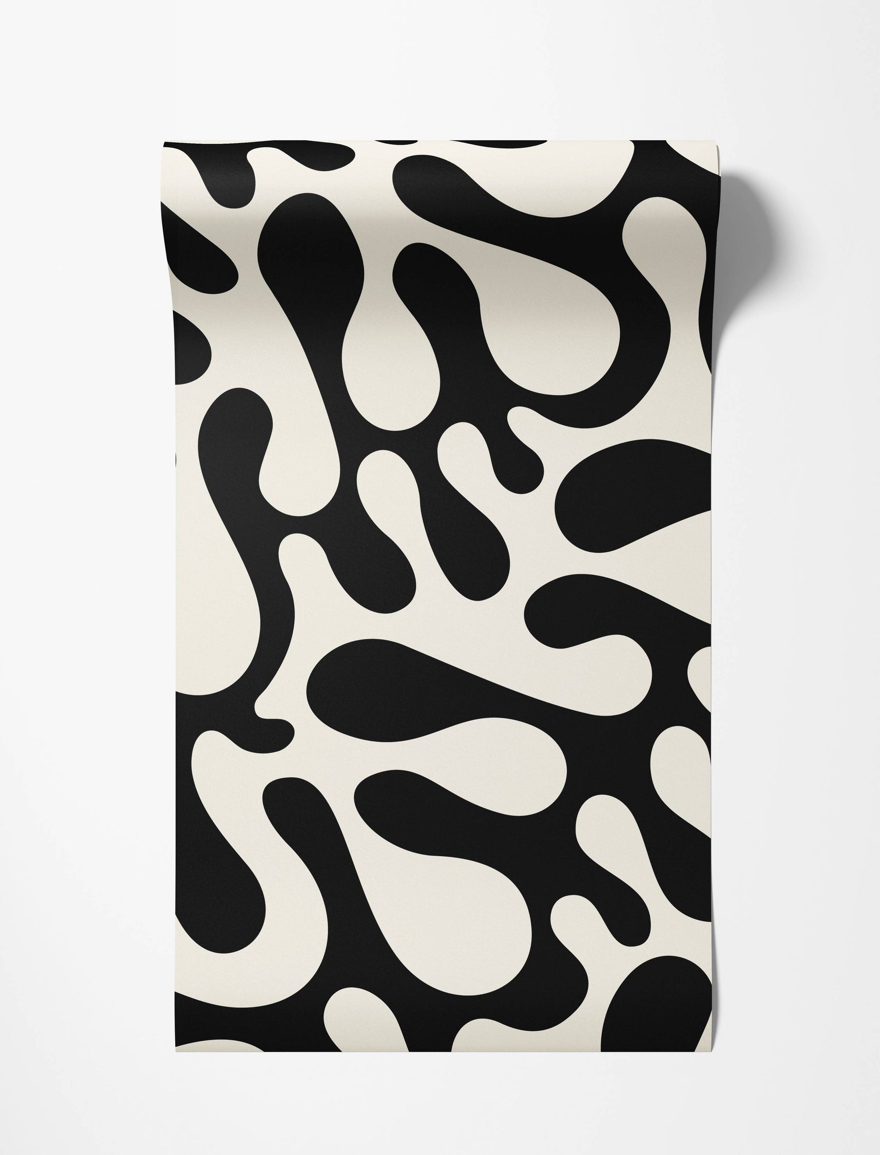 Wallpaper featuring a bold pattern of large, irregular black organic shapes on an off-white background.