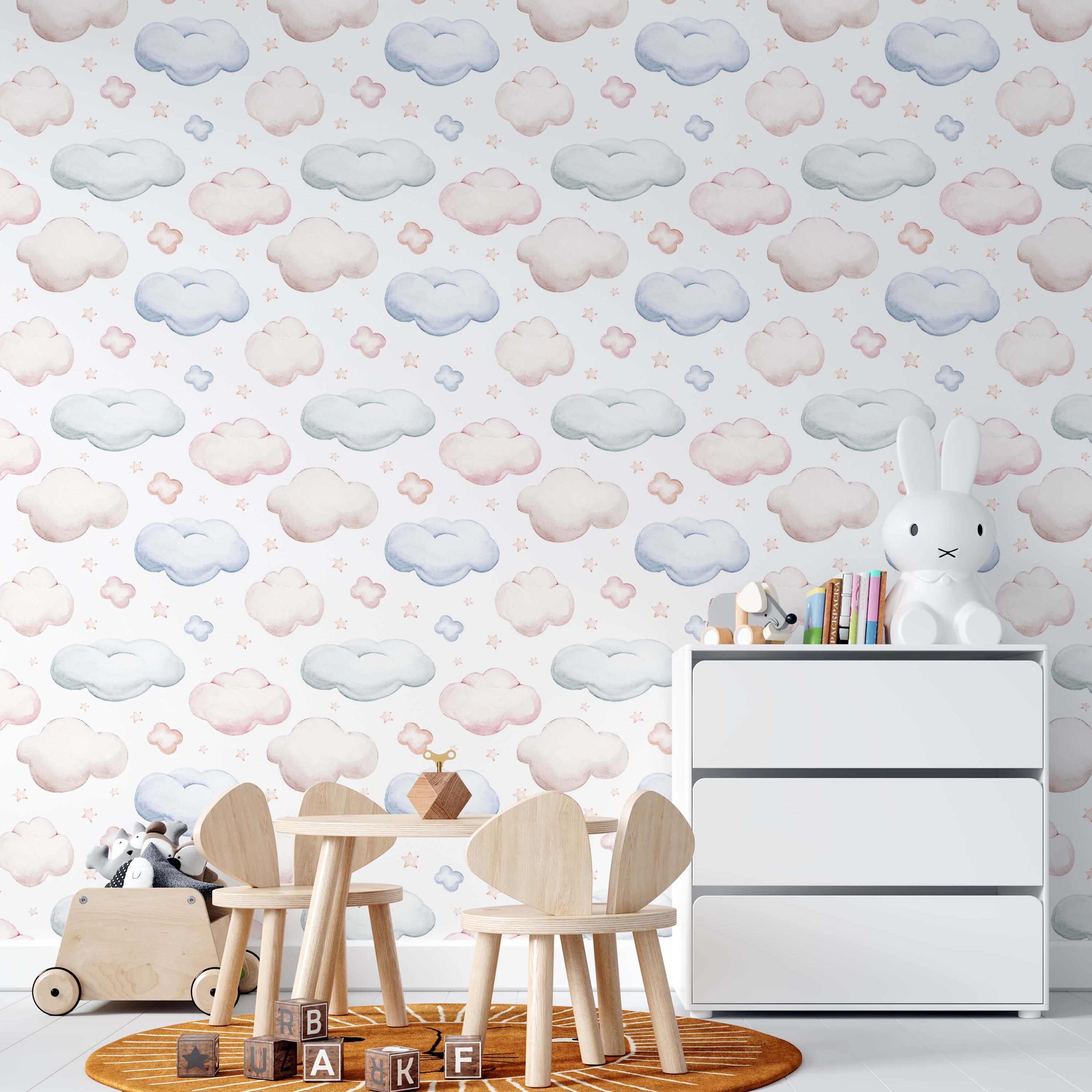 Whimsical wallpaper with soft pastel pink, blue, and light beige watercolor clouds and tiny peach-pink stars on a white background.