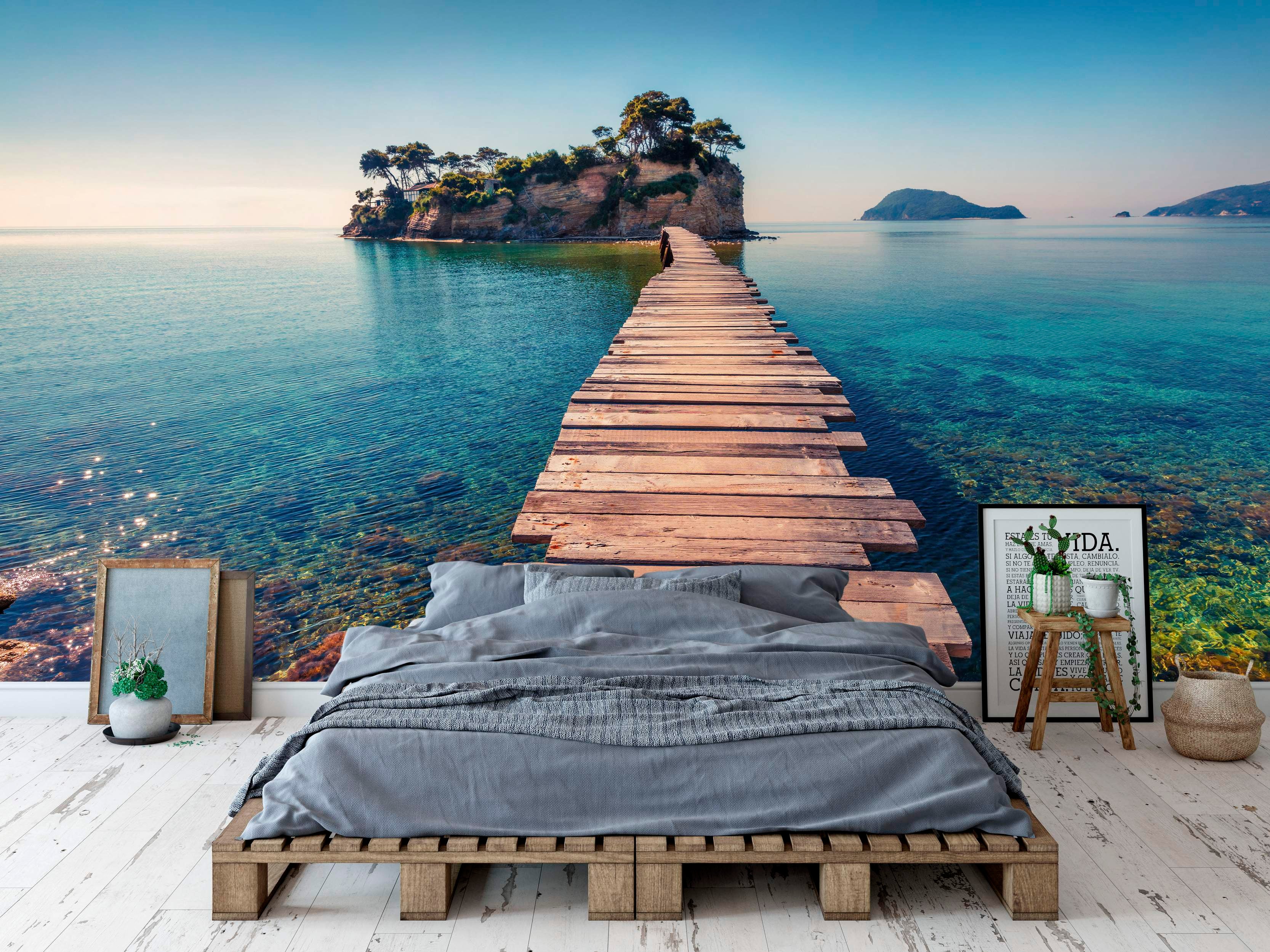 Photorealistic mural featuring a wooden pier leading to a small, green island in calm, clear turquoise water under a bright blue sky.