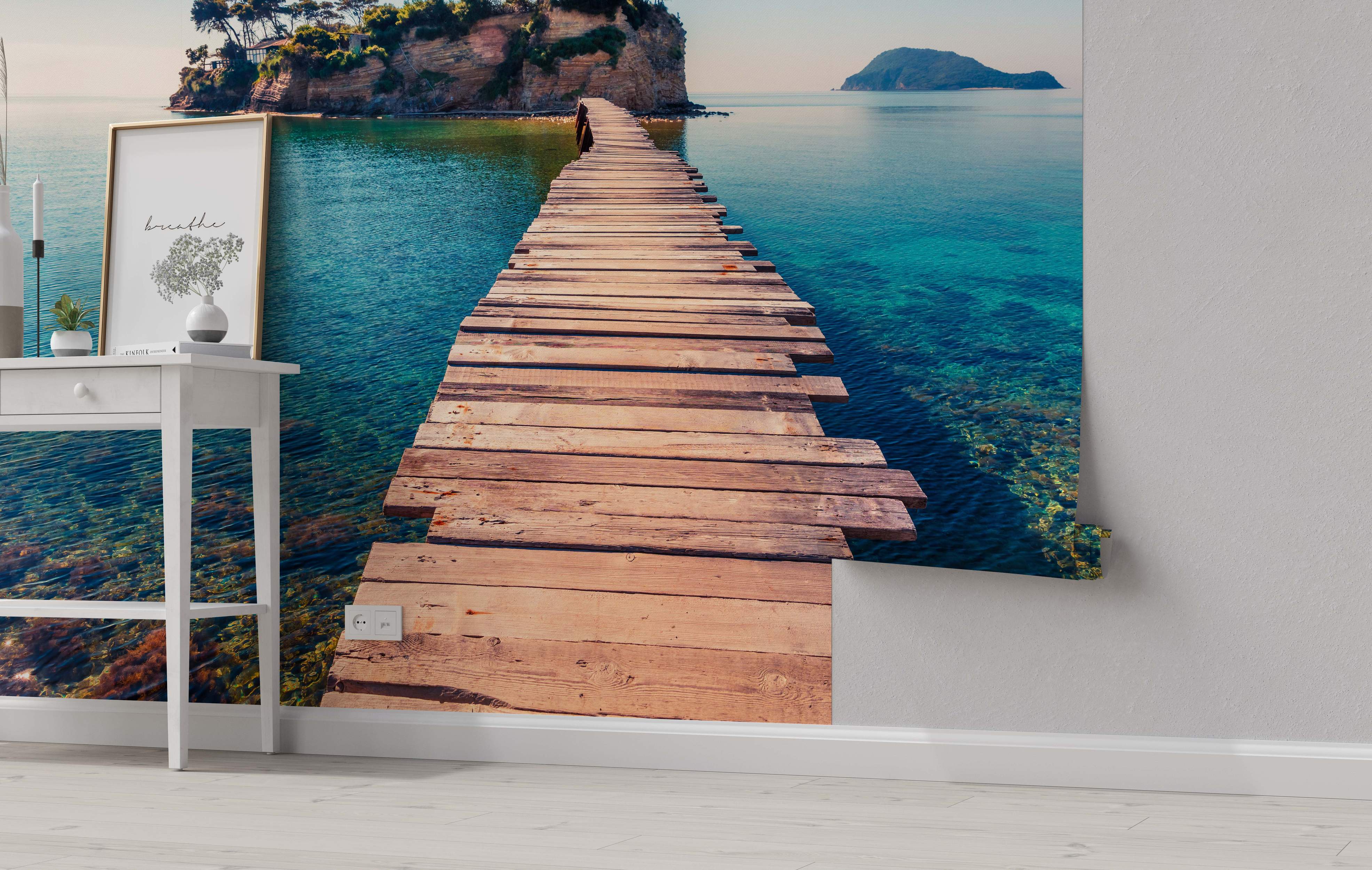 Scenic mural depicting a rustic wooden pier extending over clear turquoise water towards a rocky island with trees.