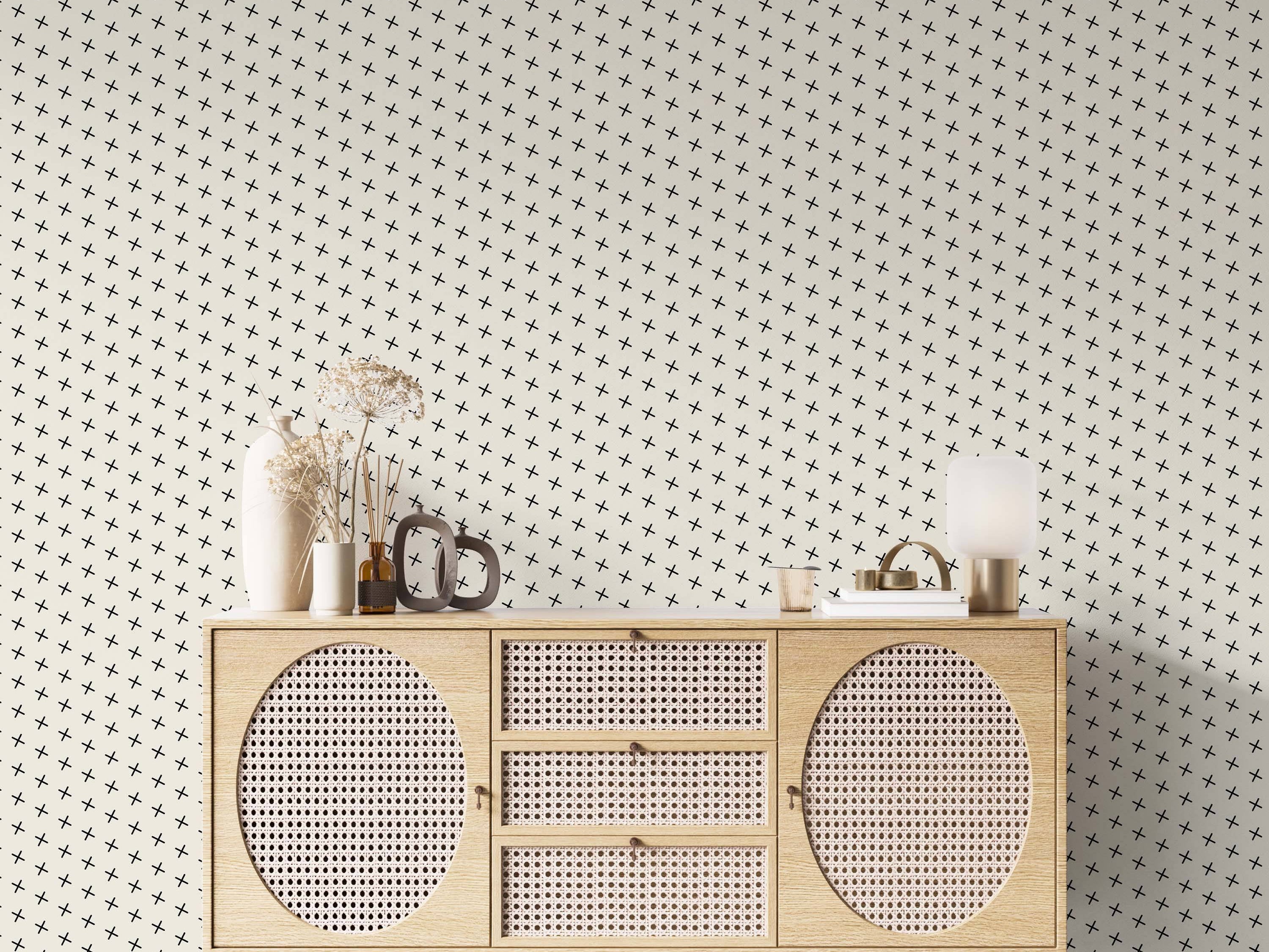 Wallpaper featuring a pattern of small black plus signs arranged diagonally on a light cream background.