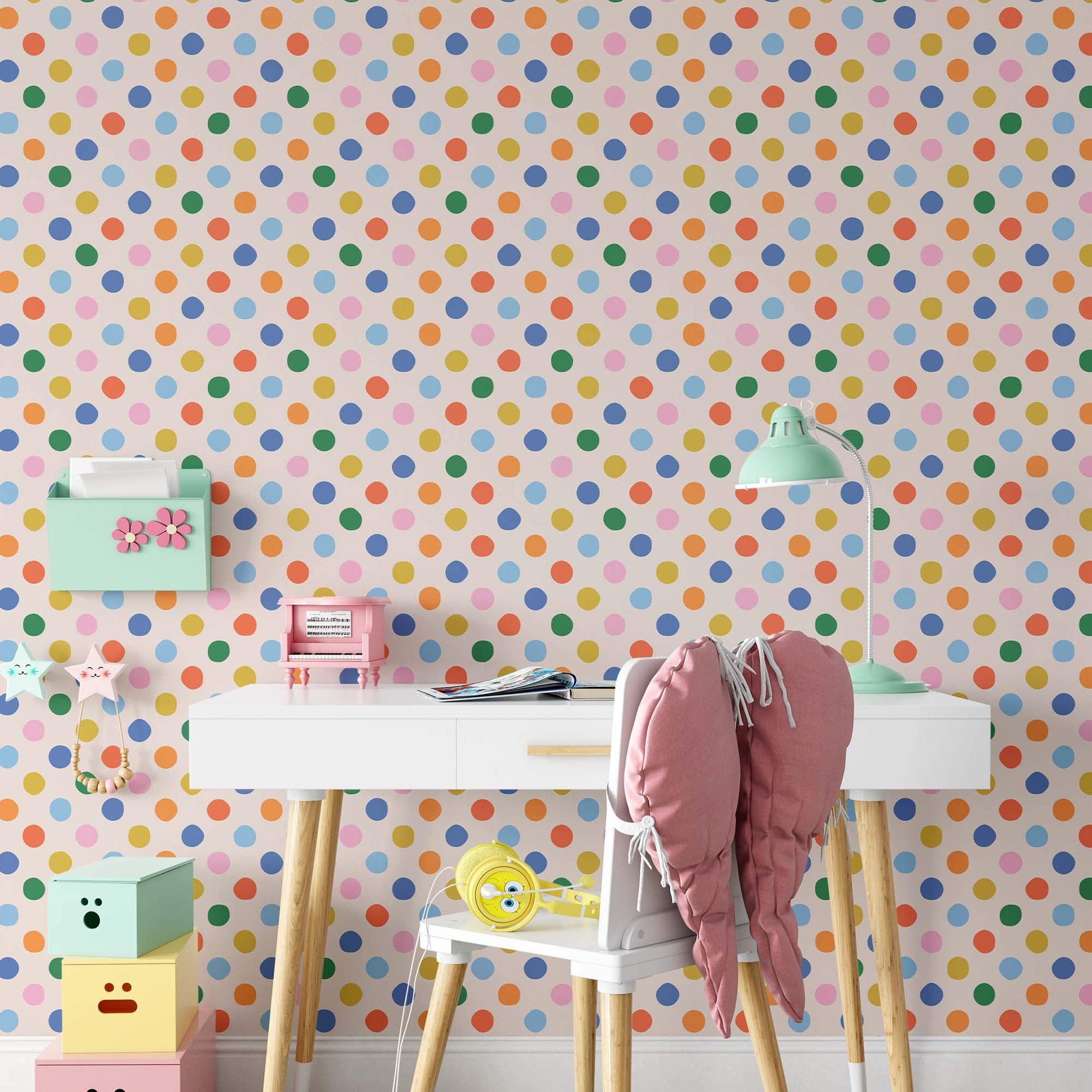 Wallpaper with a repeating pattern of multicolor polka dots including blue, green, yellow, orange, and pink on a light cream background.