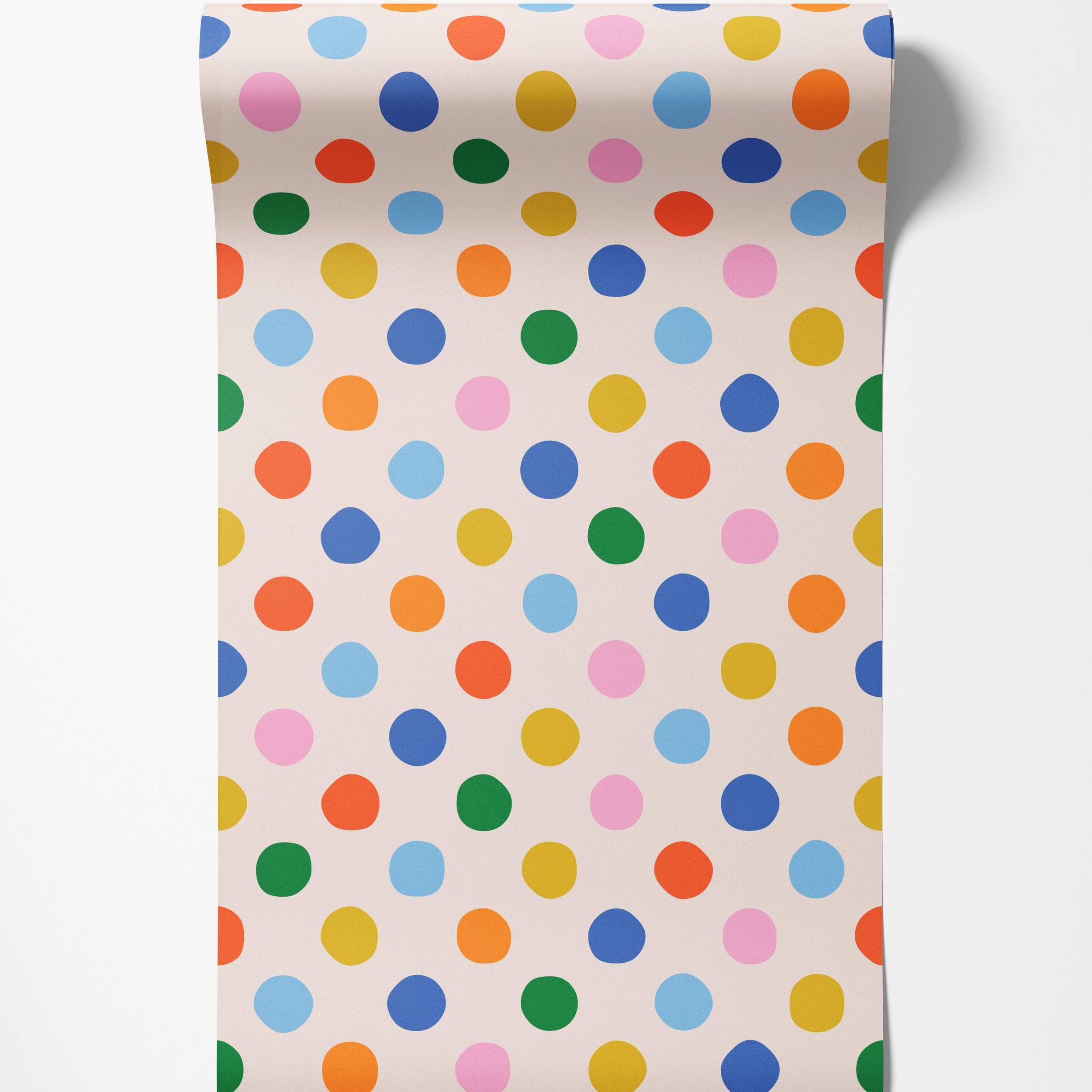 Wallpaper featuring a playful pattern of multicoloured polka dots in blue, green, yellow, orange, and pink on a light cream background.
