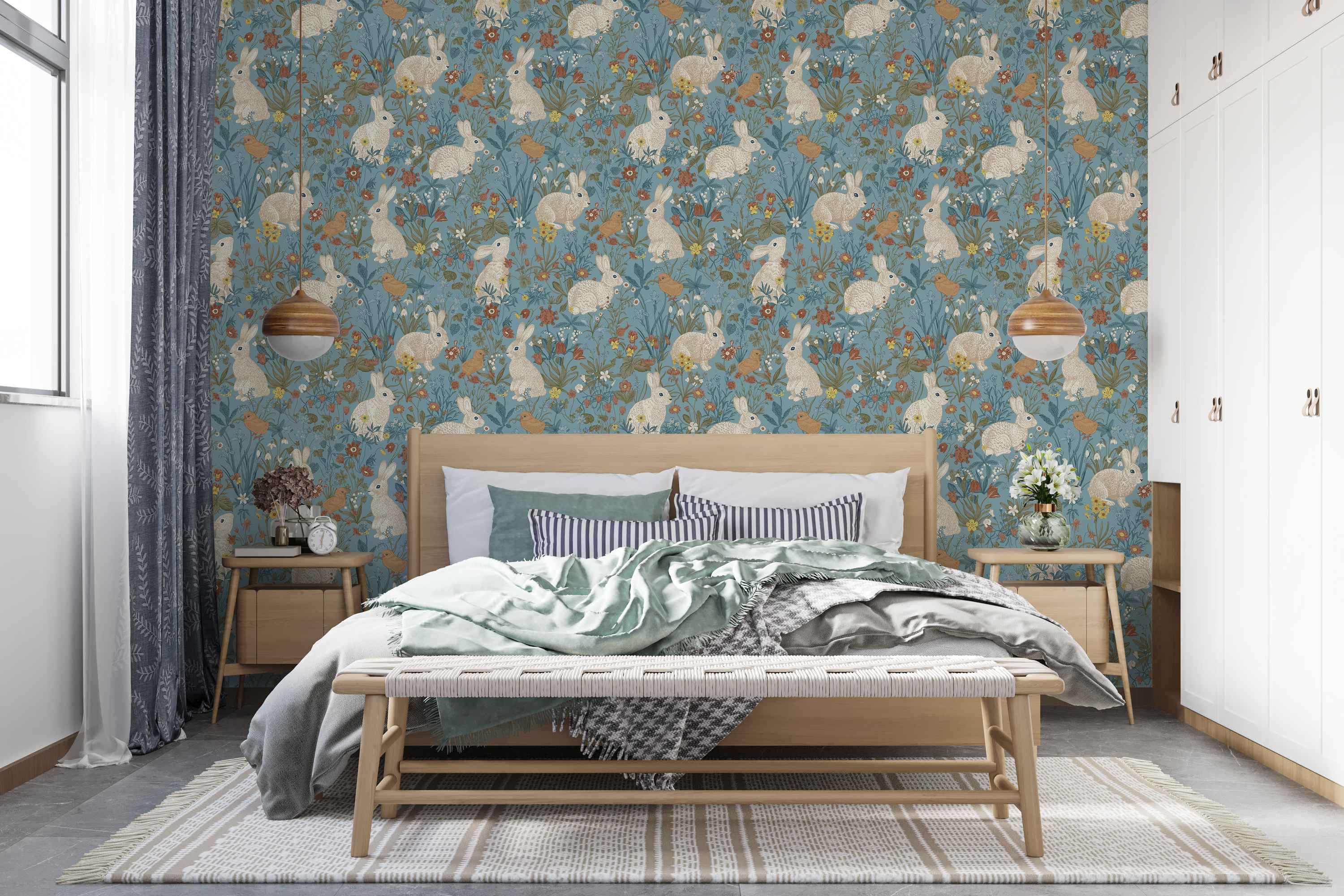 Blue wallpaper with a repeating pattern of illustrated beige rabbits, brown birds, and colorful wildflowers.