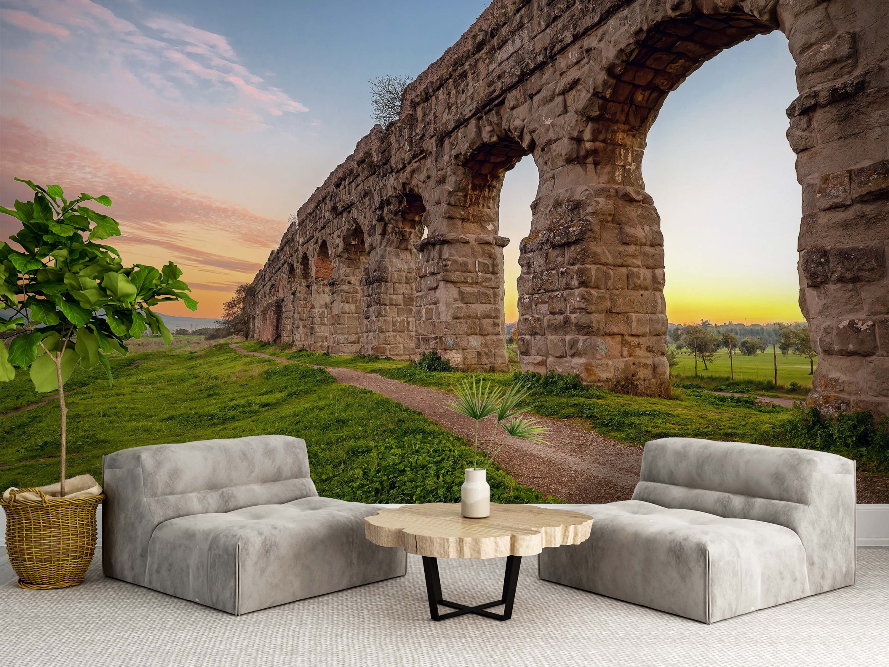 A scenic mural of ancient Roman aqueduct ruins in a green field under a colorful sunset sky.