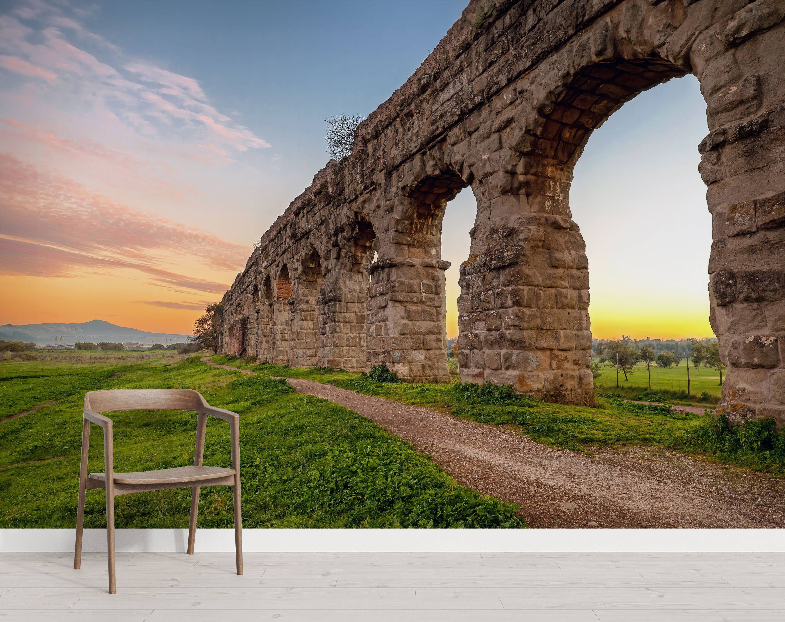 A scenic mural of an ancient Roman aqueduct curving through a green landscape during a vibrant sunset.