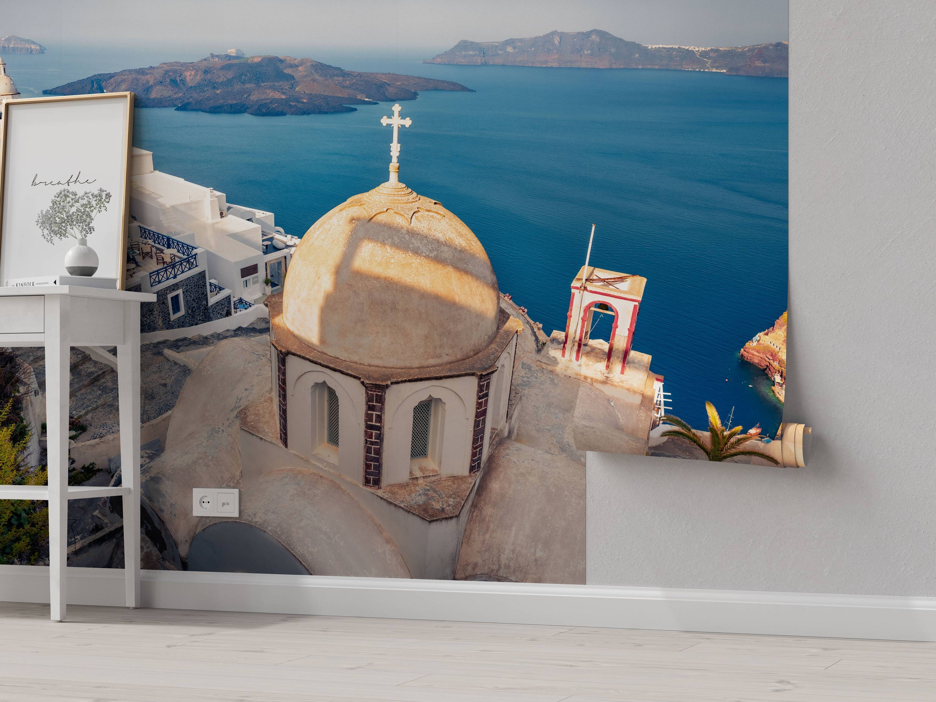 A scenic wall mural of Santorini, featuring a sunlit church dome overlooking the deep blue Aegean Sea and volcanic islands.