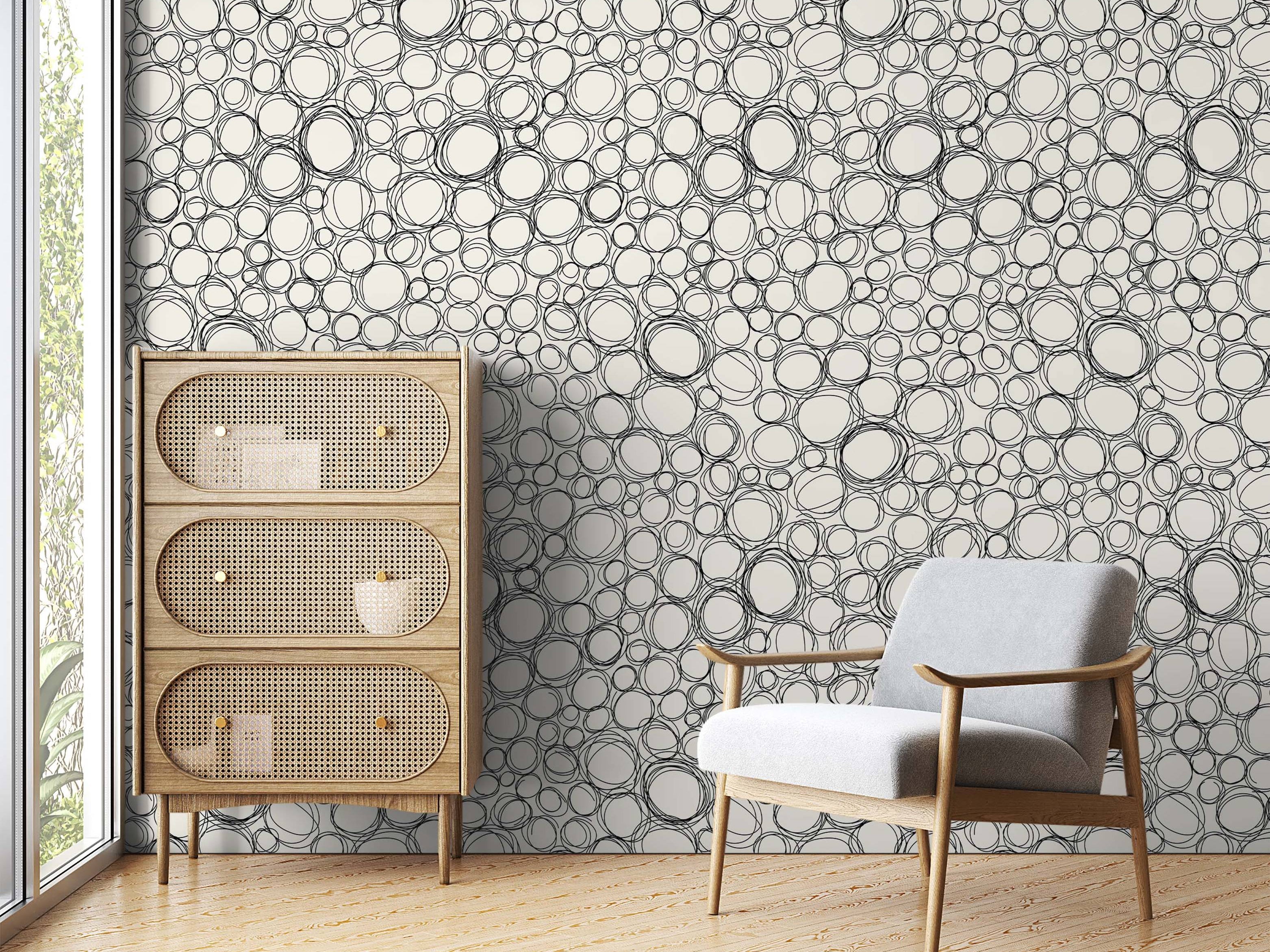 Wallpaper featuring a dense pattern of overlapping, hand-drawn black scribble circles on a cream background.