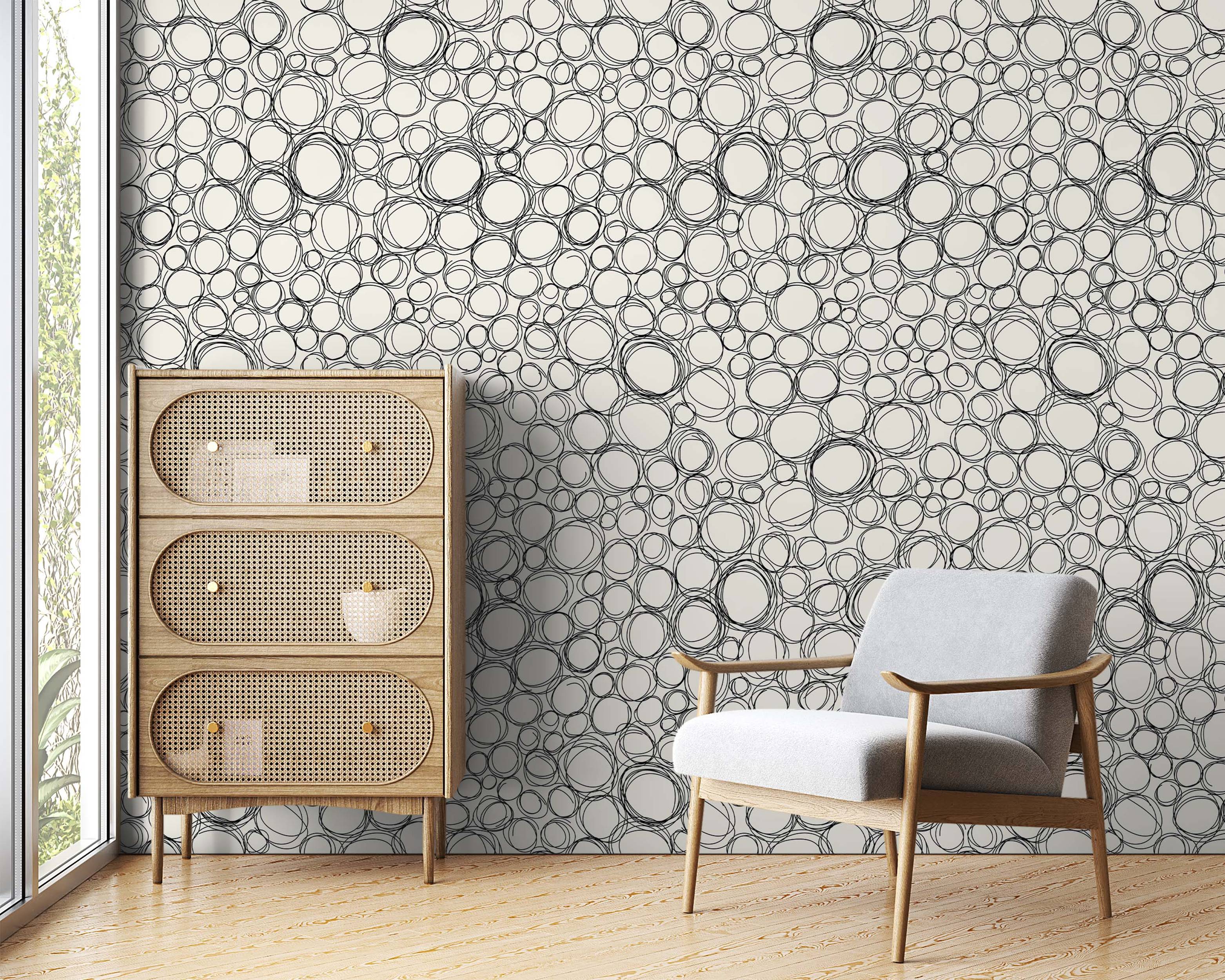 Wallpaper featuring a dense pattern of overlapping, hand-drawn black scribble circles on a cream background.