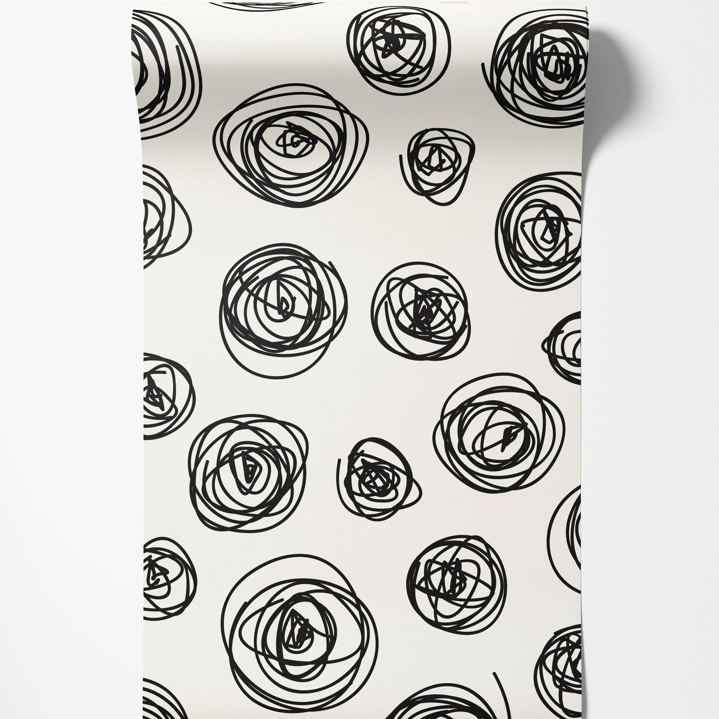 Wallpaper featuring a pattern of hand-drawn black scribble circles of various sizes on an off-white background.