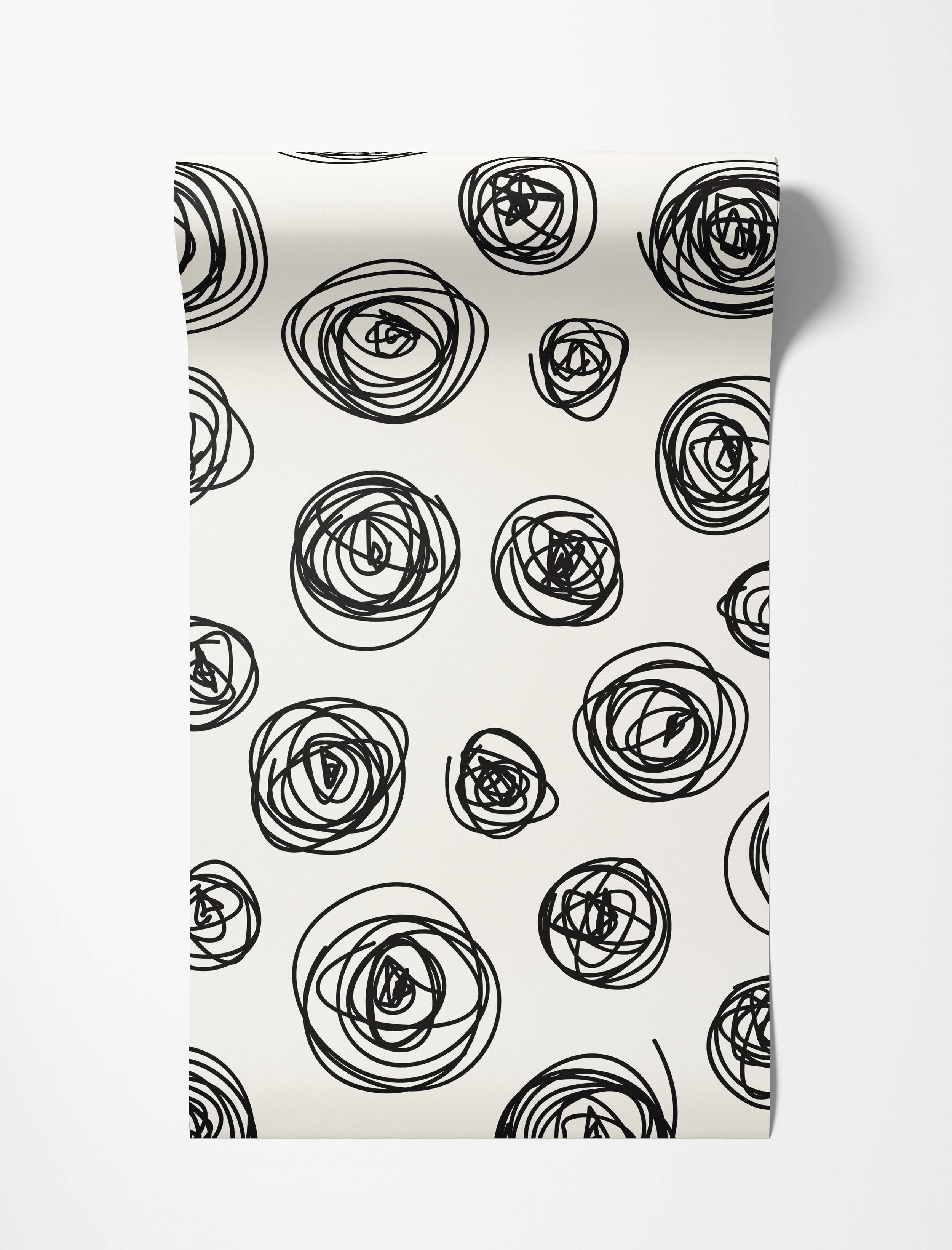 Wallpaper featuring a pattern of hand-drawn black scribble circles of various sizes on an off-white background.