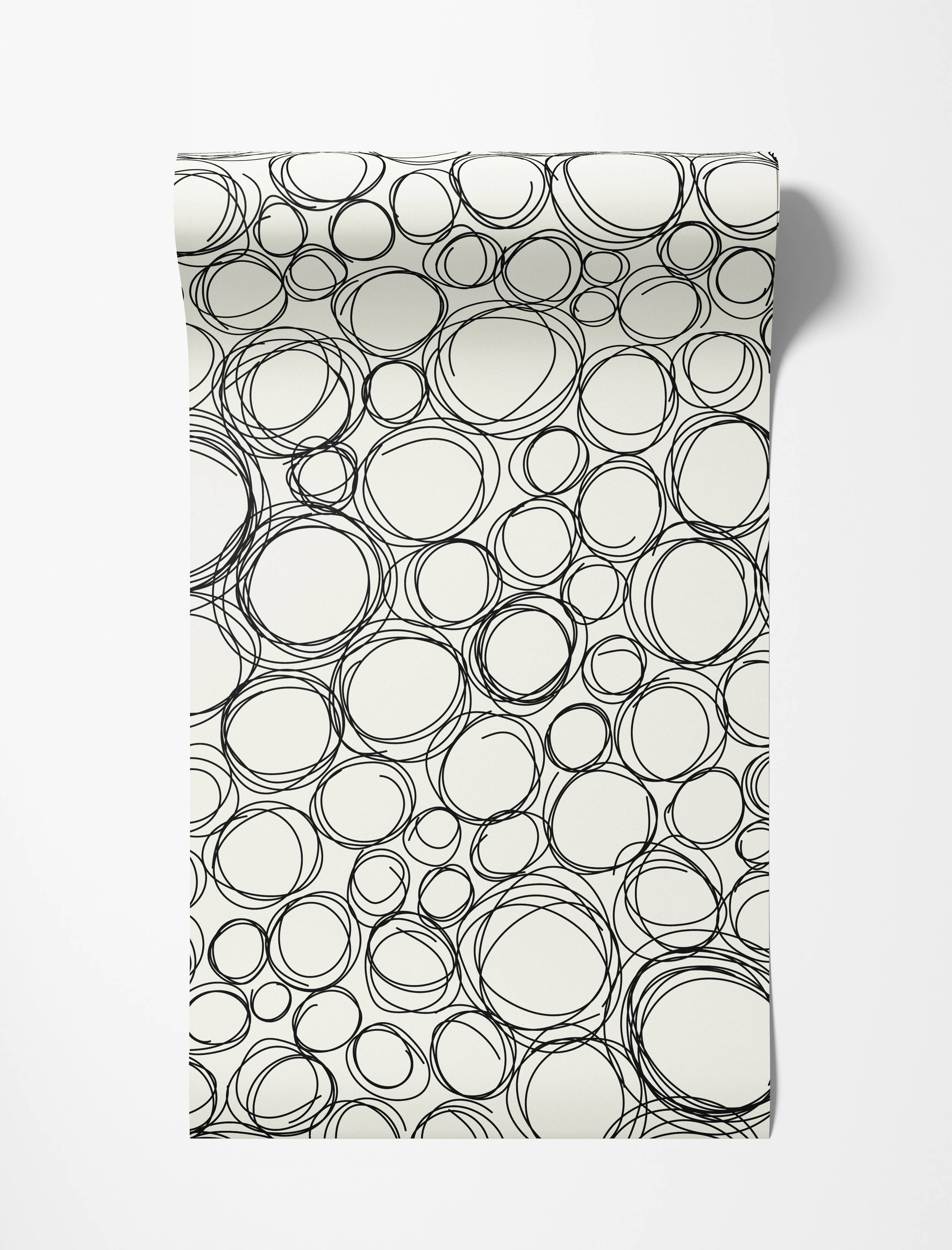 Wallpaper with a pattern of overlapping, hand-drawn black scribble circles and ovals on an off-white background.