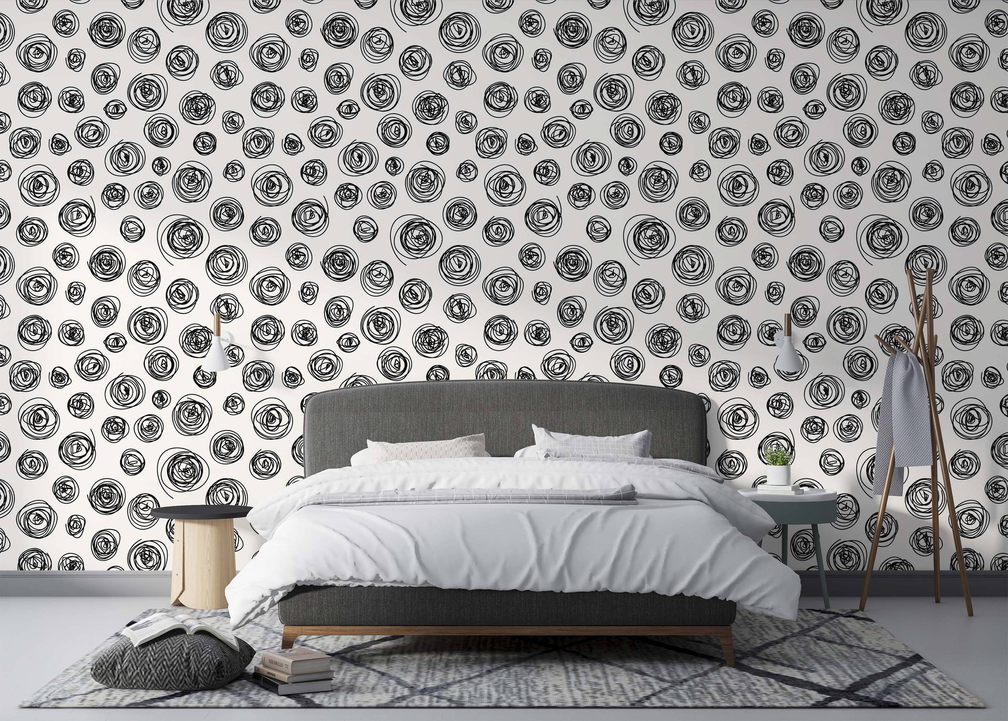 Wallpaper featuring a pattern of hand-drawn black scribble swirls on a light off-white background.
