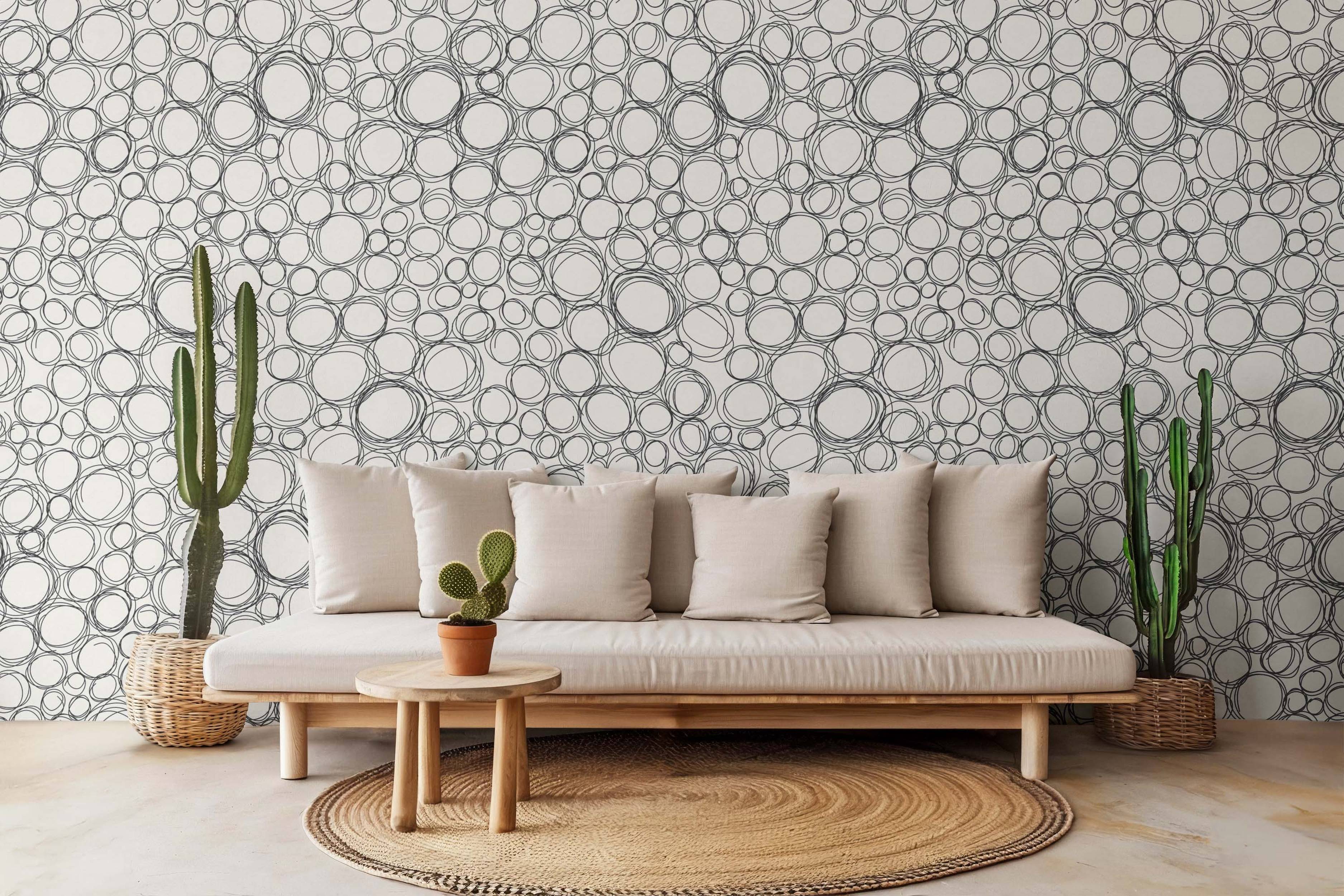 Wallpaper featuring a pattern of black hand-drawn overlapping scribble circles on an off-white background.