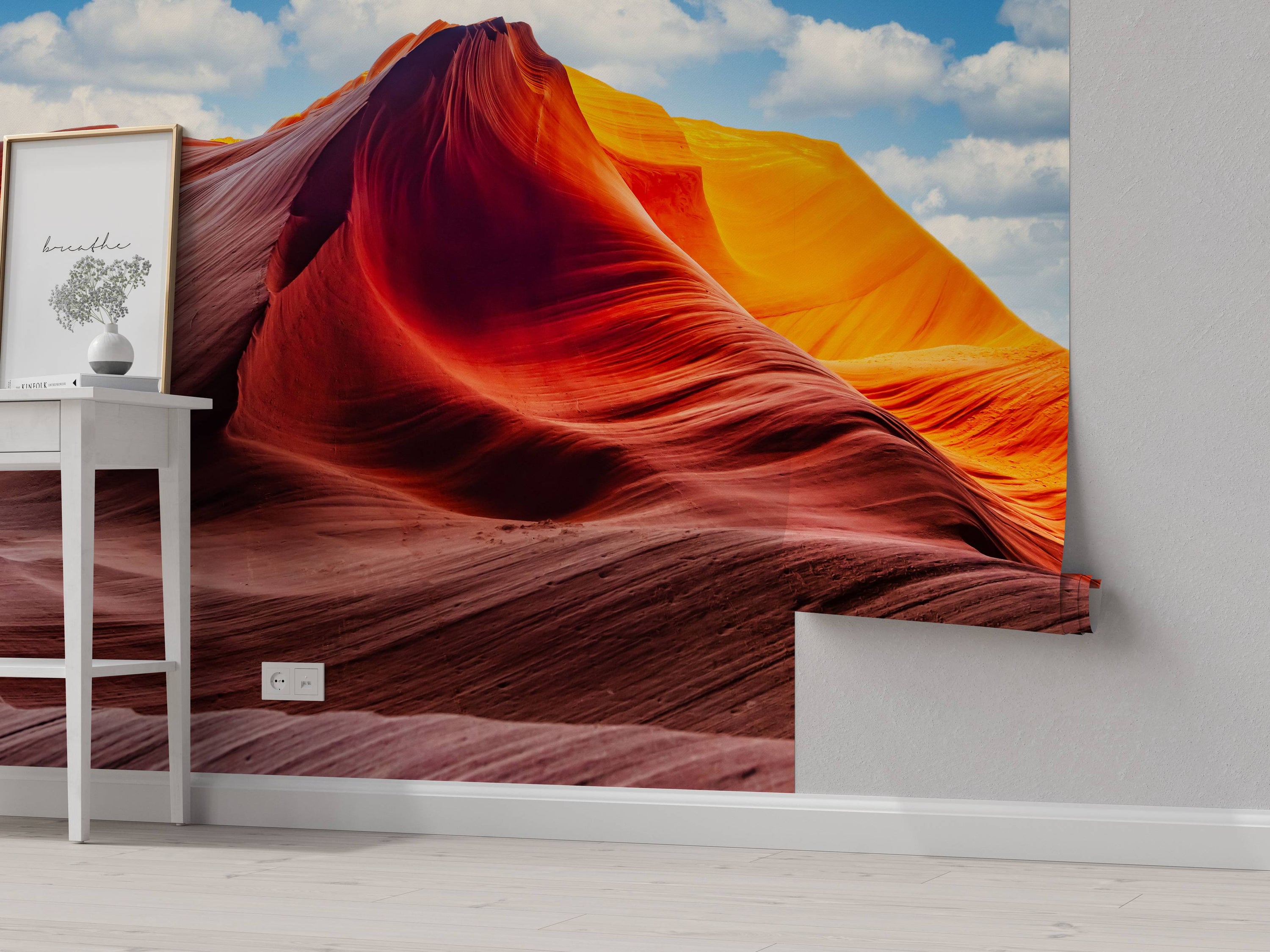 Photographic wall mural of a slot canyon with flowing red and orange rock formations under a bright blue sky with clouds.