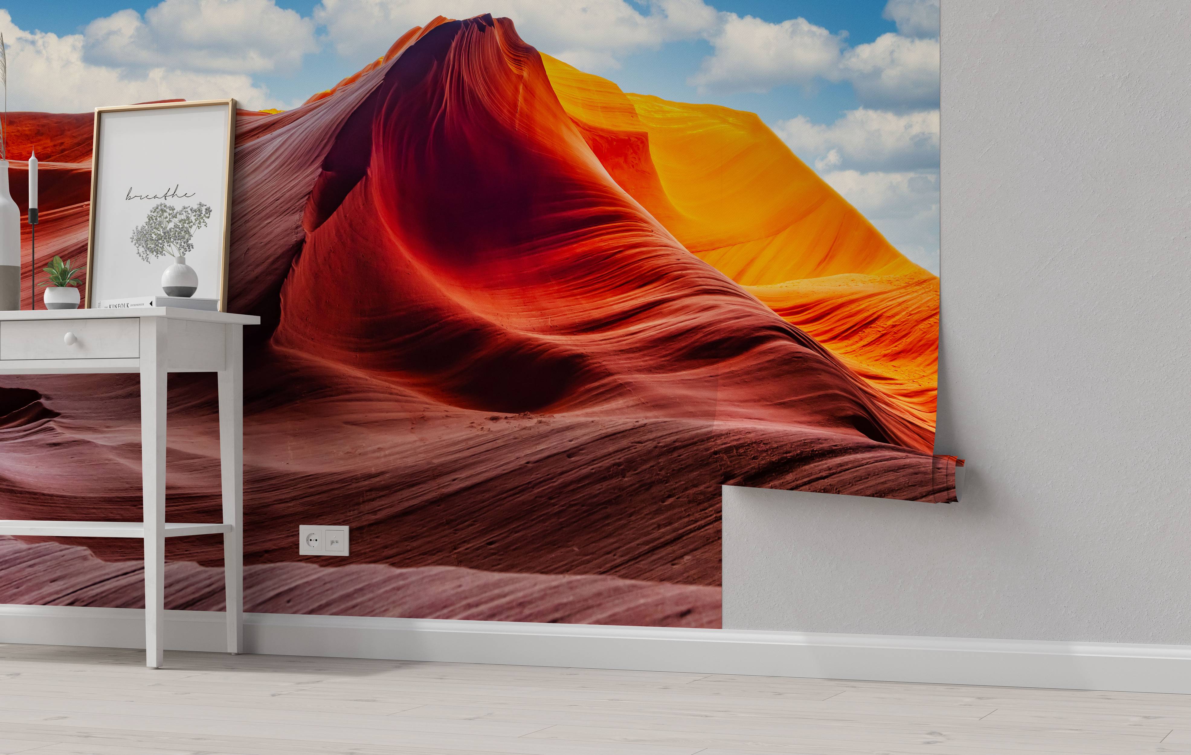 Photographic wall mural of a slot canyon with flowing red and orange rock formations under a bright blue sky with clouds.