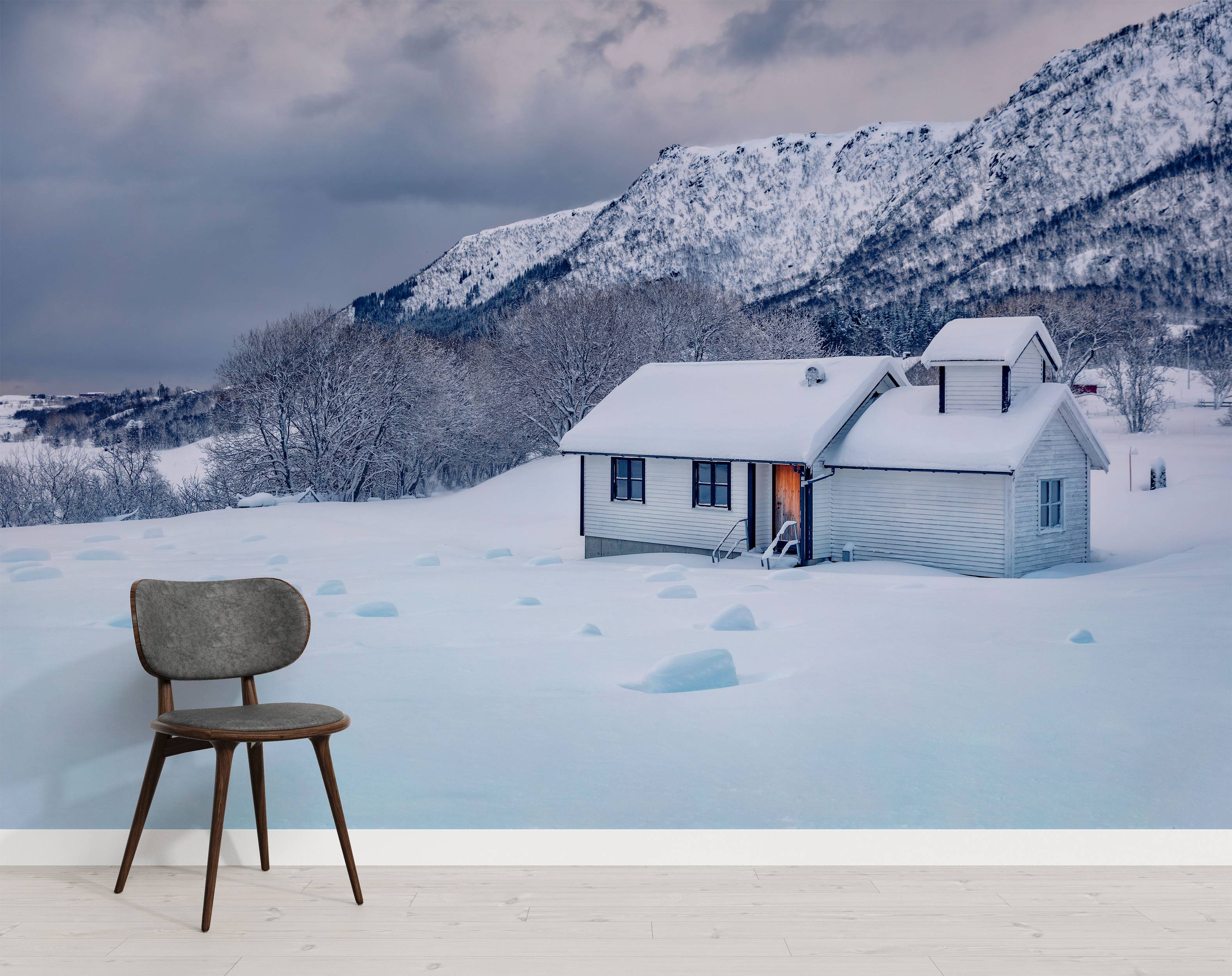 A scenic wall mural of a solitary white house in a vast, snowy landscape, with snow-covered mountains under a cloudy sky.