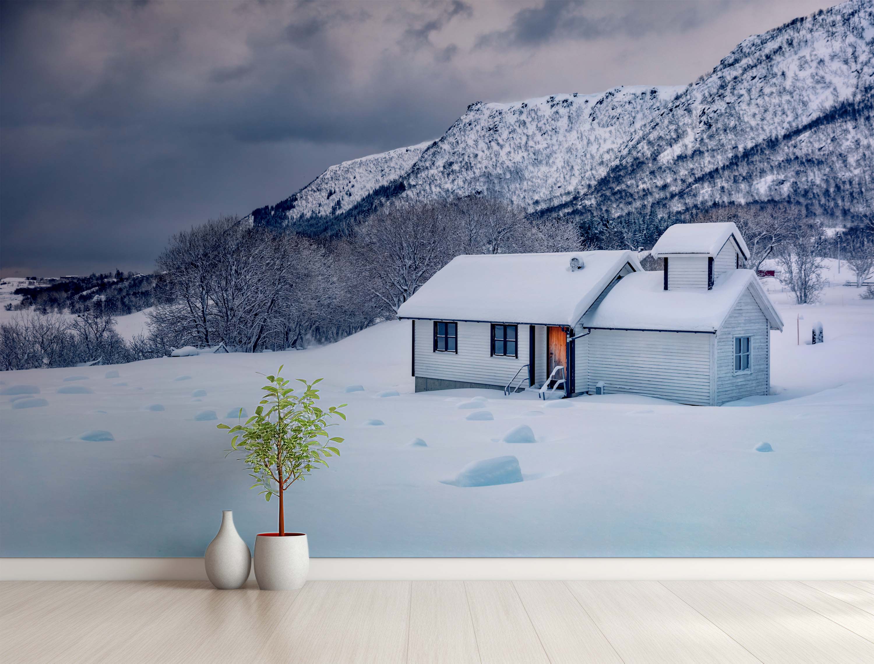 A photorealistic mural of a white cabin blanketed in snow, set against a dramatic, cloudy mountain landscape.