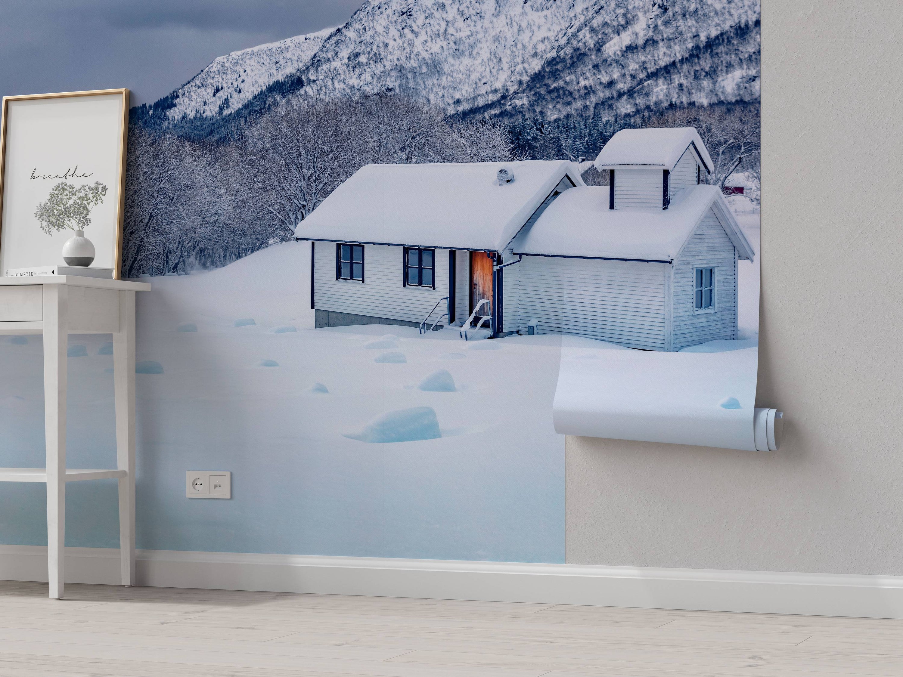 A photorealistic wall mural of a white house nestled in a snowy valley at the base of a large, snow-covered mountain.