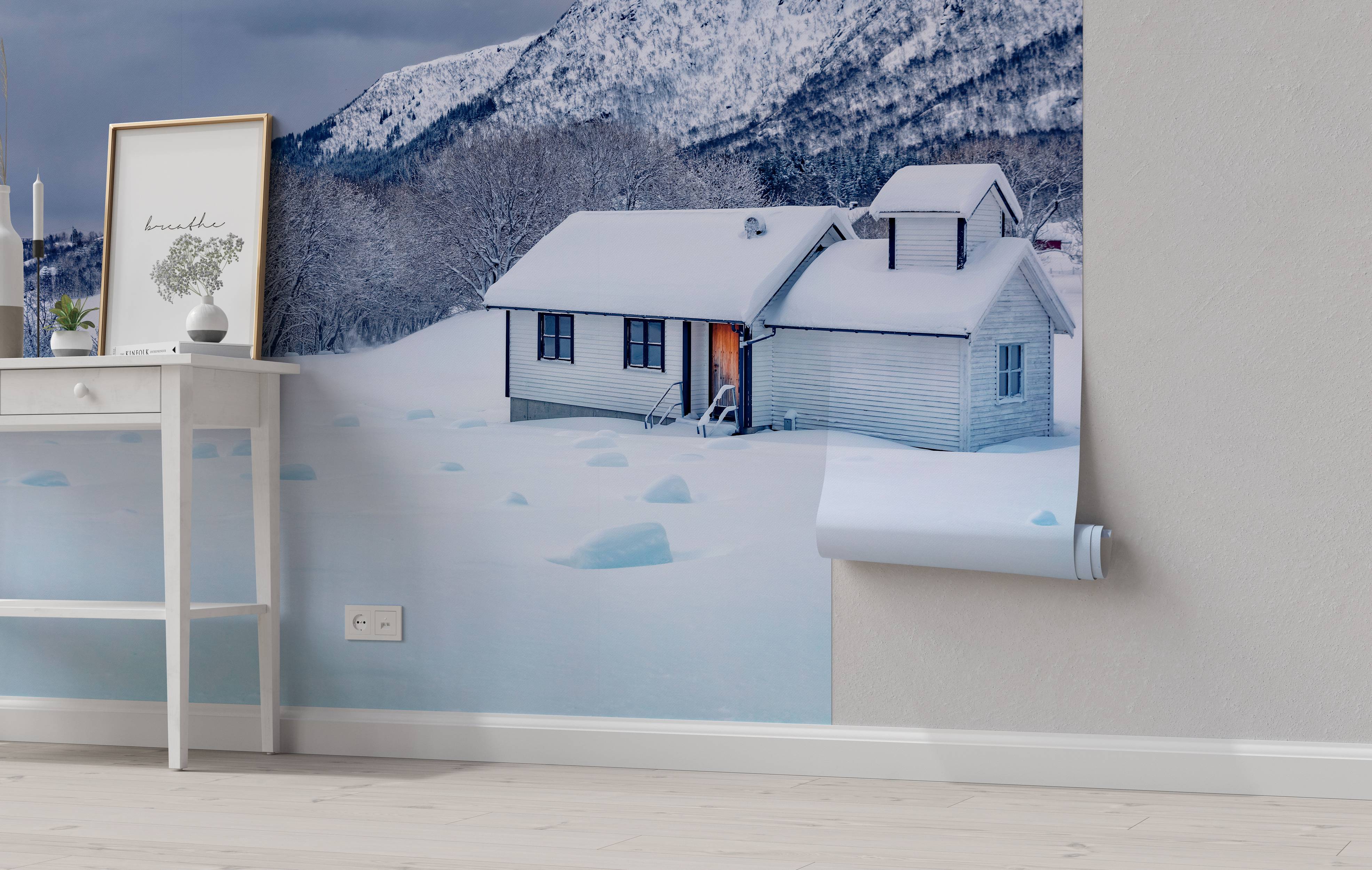 A photorealistic wall mural of a white house nestled in a snowy valley at the base of a large, snow-covered mountain.